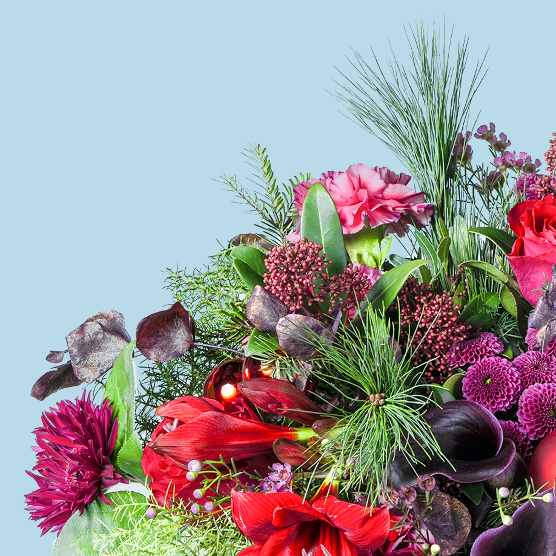 Ein lebendiger Strauß verschiedener bunter Blumen, darunter rote Mohnblumen, rosa Nelken und violette Chrysanthemen, vor dem Hintergrund eines ruhigen blauen Himmels.