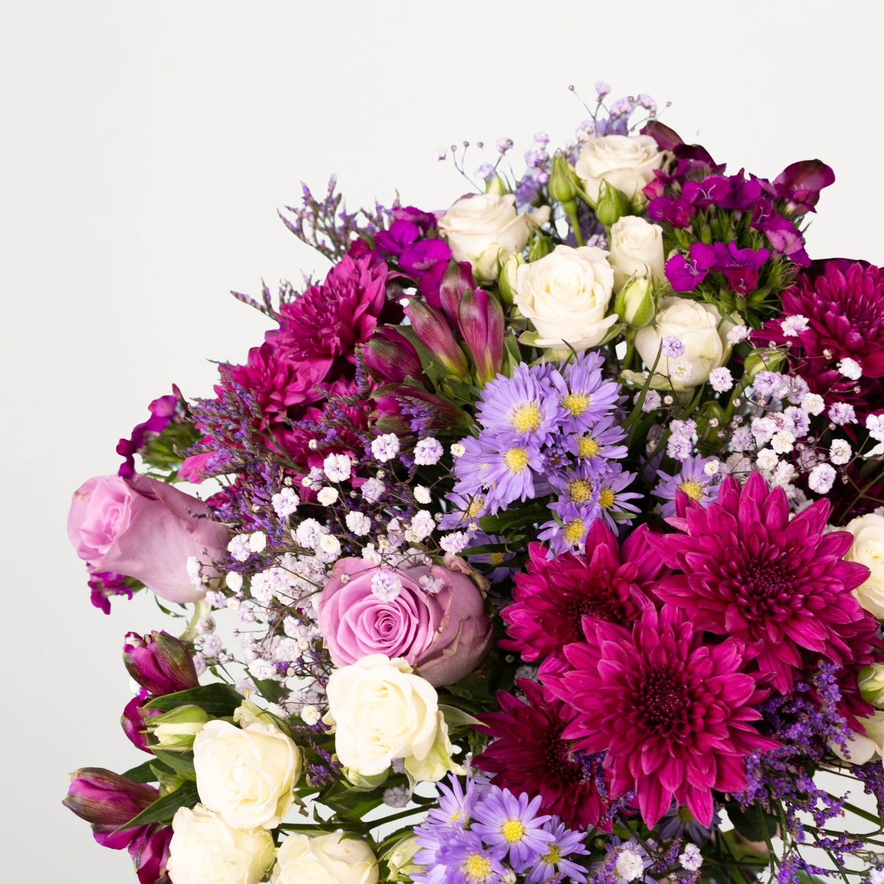 Ein farbenfroher Strauß verschiedener Blumen, darunter rosa Rosen, violette und weiße Gänseblümchen und dunkelrote Dahlien, arrangiert vor einem schlichten weißen Hintergrund.
