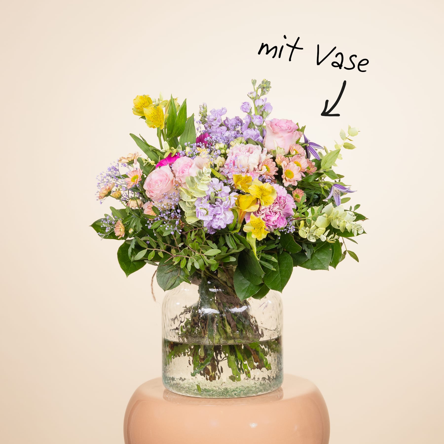 Ein wunderschöner Strauß bunter Blumen, darunter rosa, gelbe und violette Blüten, wird in einer Glasvase vor einem schlichten, hellen Hintergrund präsentiert.