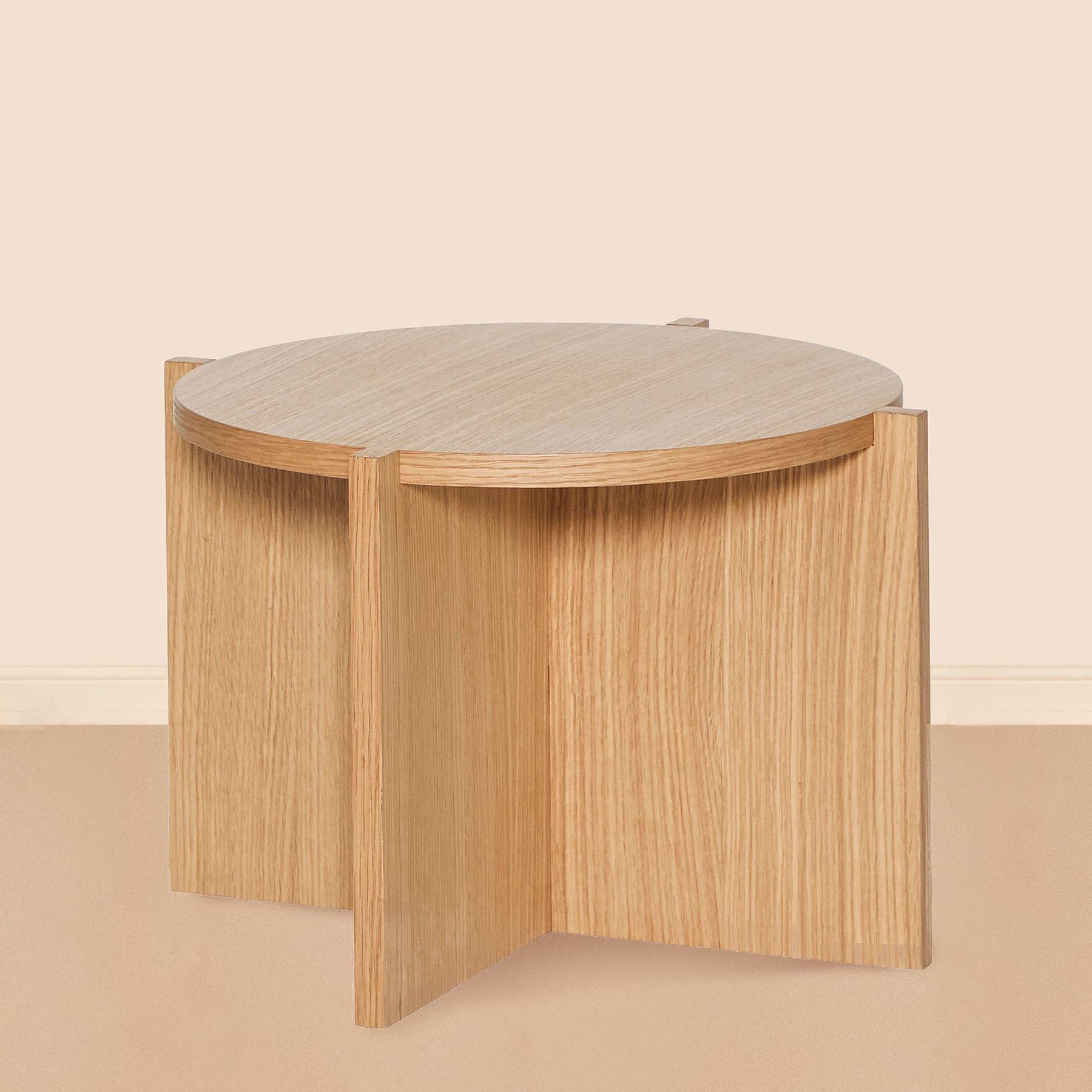 Ein Set aus zwei runden Beistelltischen oder Abschlusstischen aus Holz mit heller Holzmaserung, auf einem beigen Boden vor einer schlichten Wand platziert.