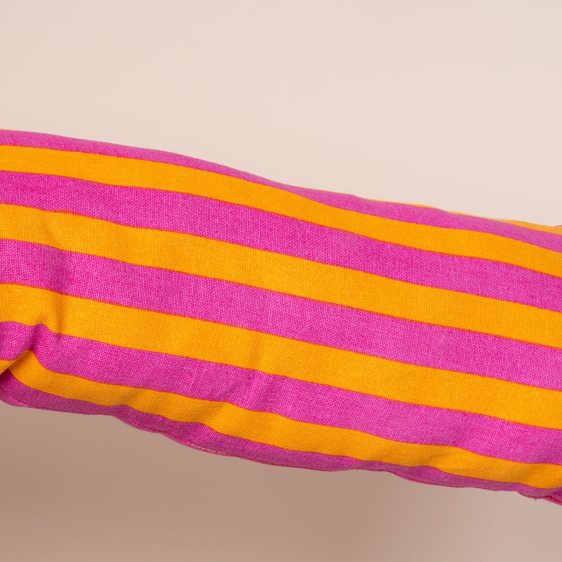 Leuchtende Streifen aus rosa und orangefarbenem Stoff füllen den Rahmen und sorgen für ein kräftiges und auffälliges Bild.