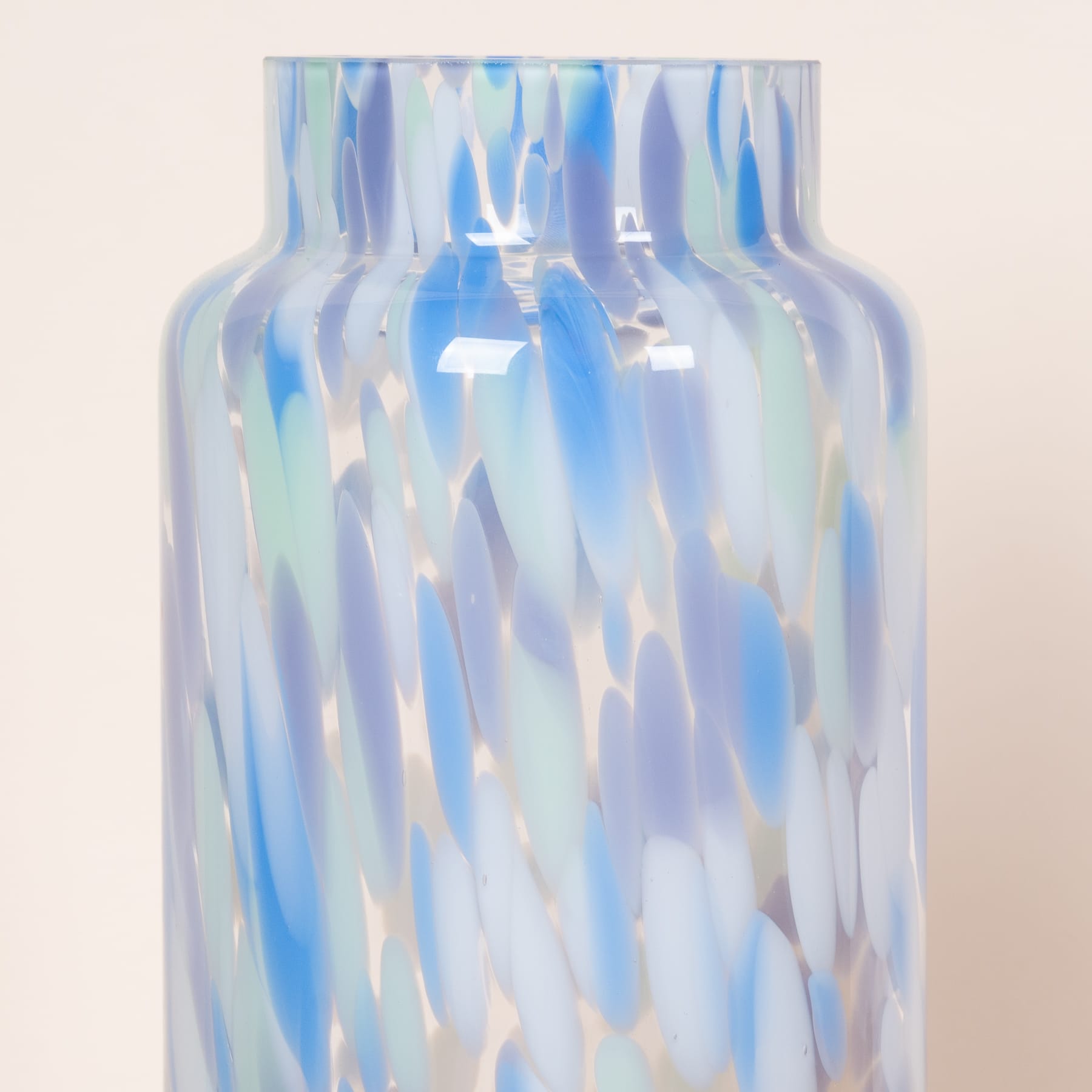 Eine Glasvase mit einem wirbelnden, schillernden Muster aus Blau-, Weiß- und einem Hauch anderer Farben, das einen faszinierenden und ätherischen visuellen Effekt erzeugt.