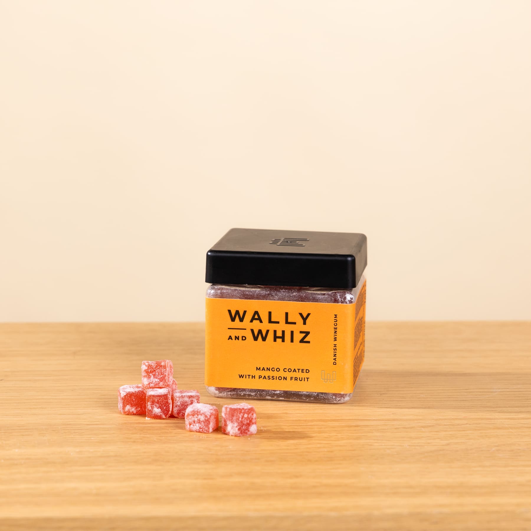 Ein Holztisch mit einer Schachtel Wally- und Whiz-Bonbons und mehreren Bonbonstücken, die auf der Oberfläche verstreut sind.