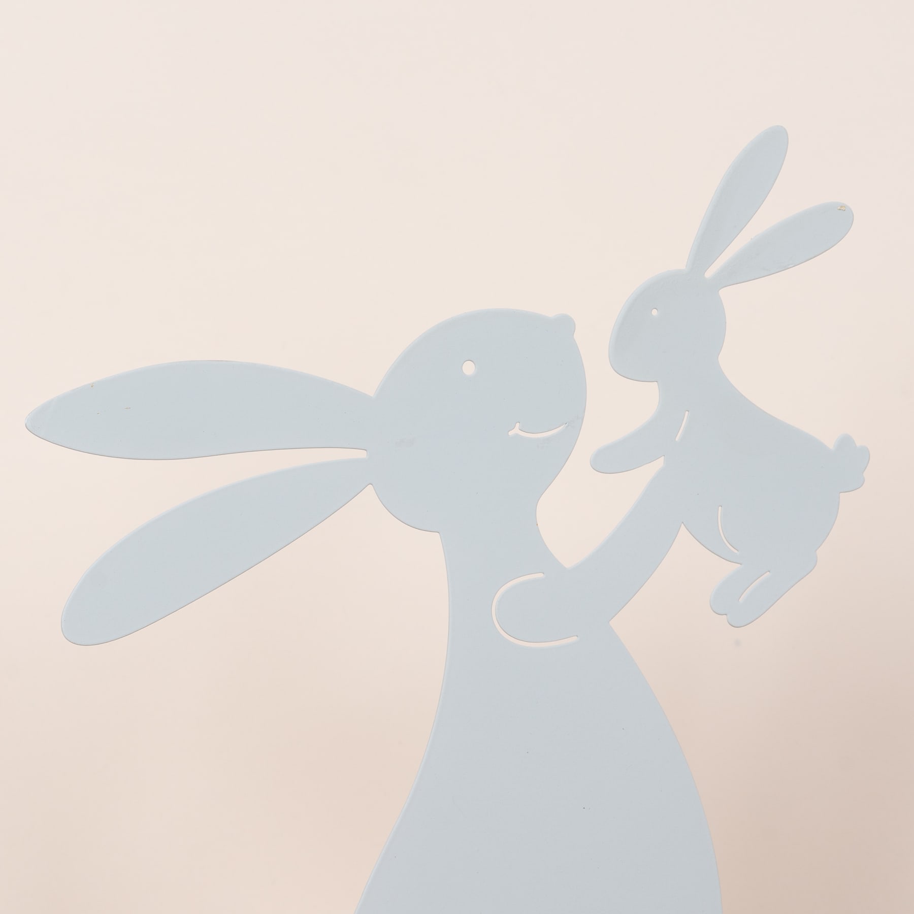 Zwei verspielte, kaninchenartige Silhouetten vor einem sanften, pastellfarbenen Hintergrund.