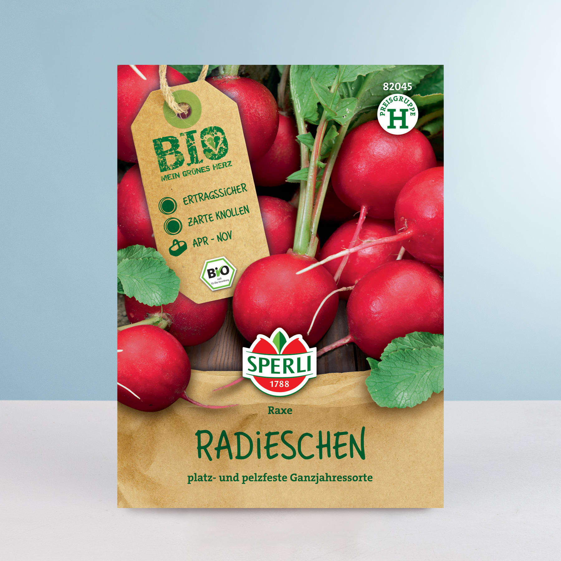 Das Bild zeigt eine Packung Bio-Radieschen mit einem grün-roten Etikett, das auf die Bio-Qualität hinweist. Die Radieschen sind von frischen grünen Blättern umgeben und stehen auf einem hellblauen Hintergrund.