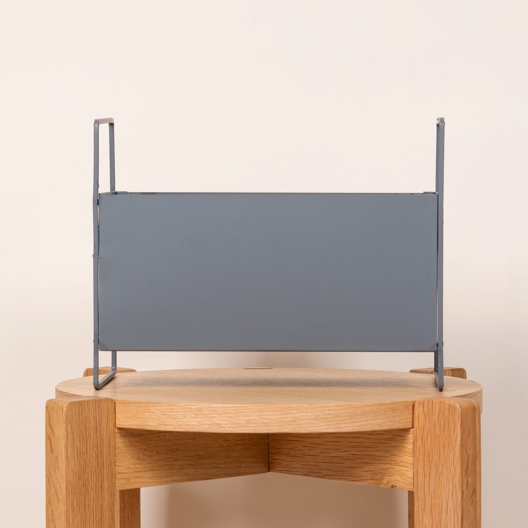 Ein grauer Metallrahmen ruht auf einer Holzplattform und schafft so ein minimalistisches und modernes Design.