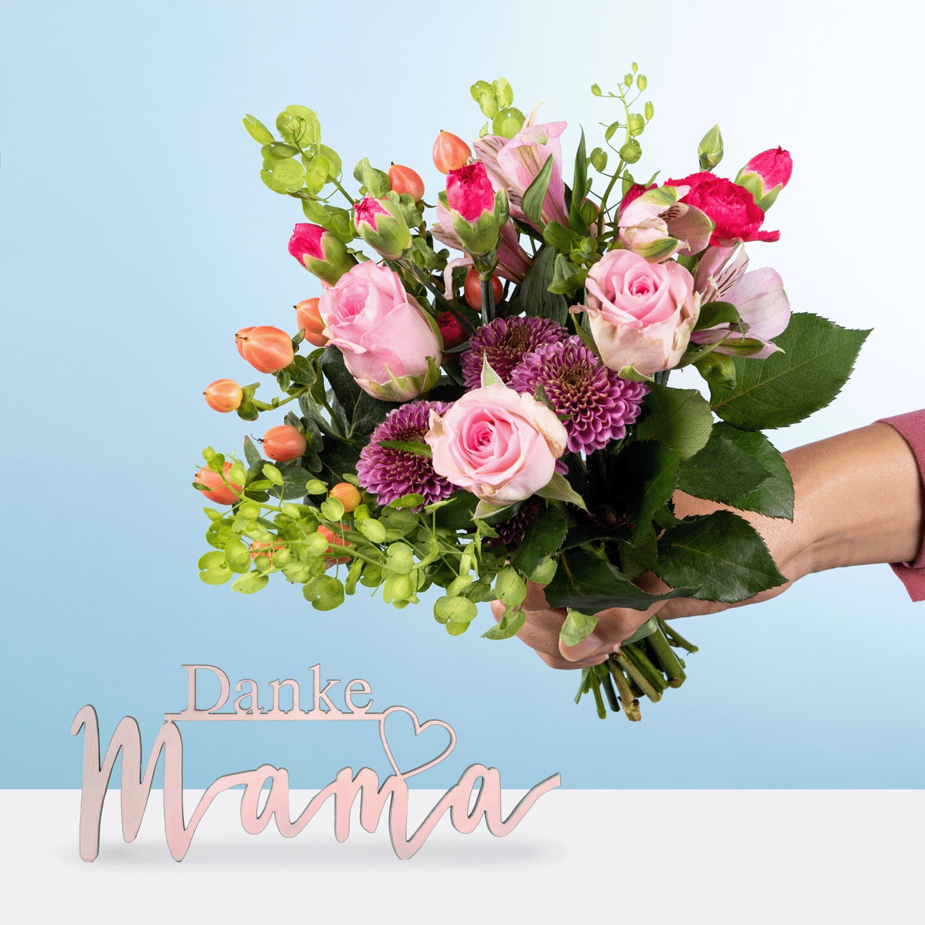 Ein farbenfroher Strauß aus rosa Rosen, lila Chrysanthemen und grünem Laub wird vor einem hellblauen Hintergrund in den Händen gehalten. Im Vordergrund ist der Text „Danke Mama“ zu sehen.