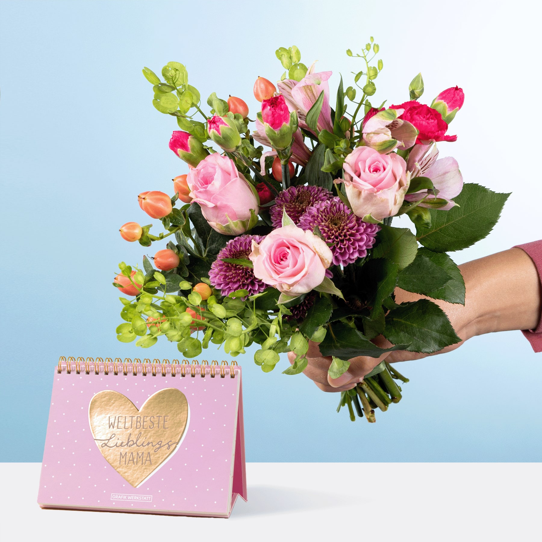 Ein leuchtender Strauß aus rosa Rosen, lila Chrysanthemen und Grünpflanzen in den Händen einer Person, mit einer rosa Karte im Kalenderstil im Vordergrund.
