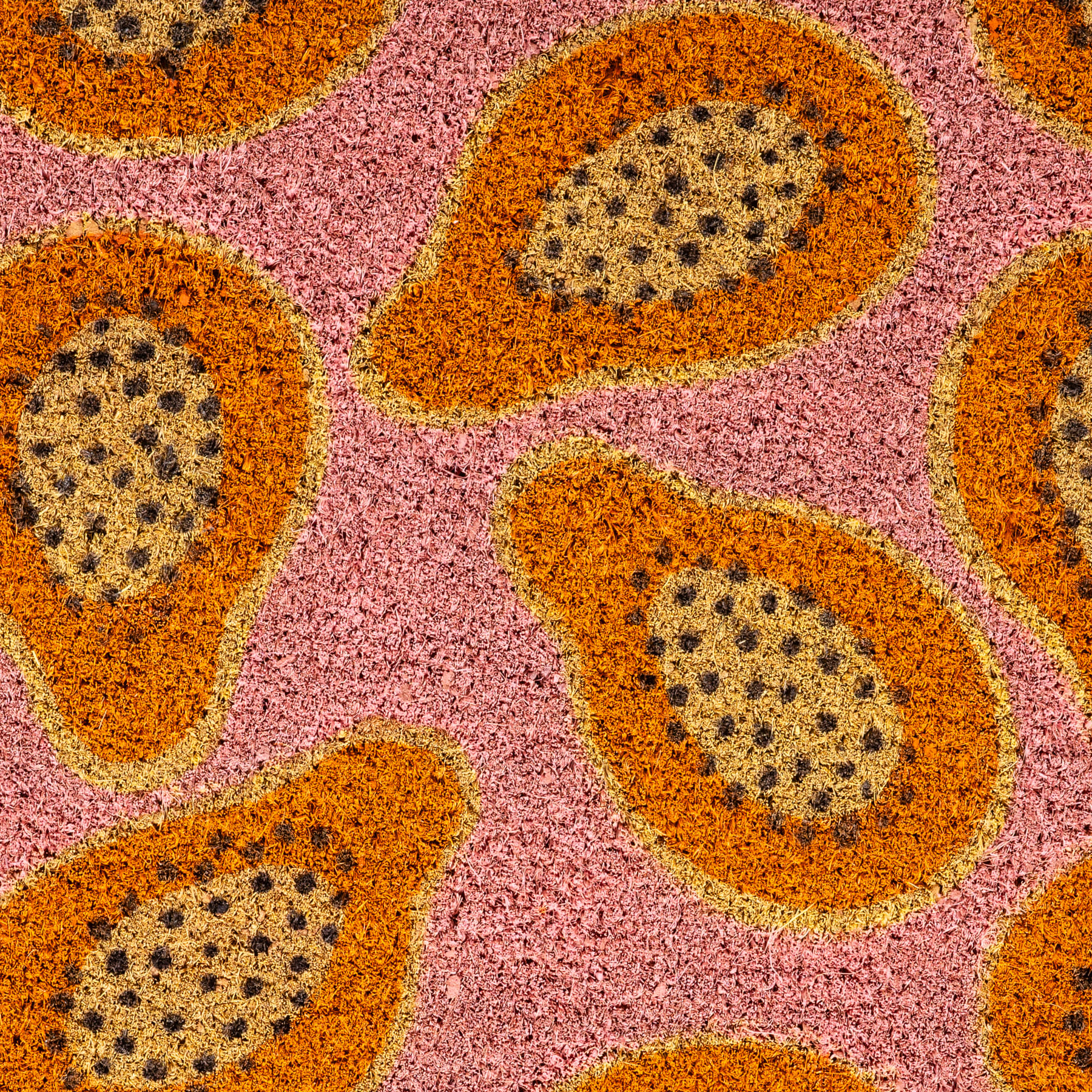 Das Bild zeigt ein lebendiges und abstraktes Muster mit großen, abgerundeten Formen in Orange- und Rosatönen und kleineren schwarzen Punkten, die über die gesamte Komposition verstreut sind, vor einem hellrosa Hintergrund.