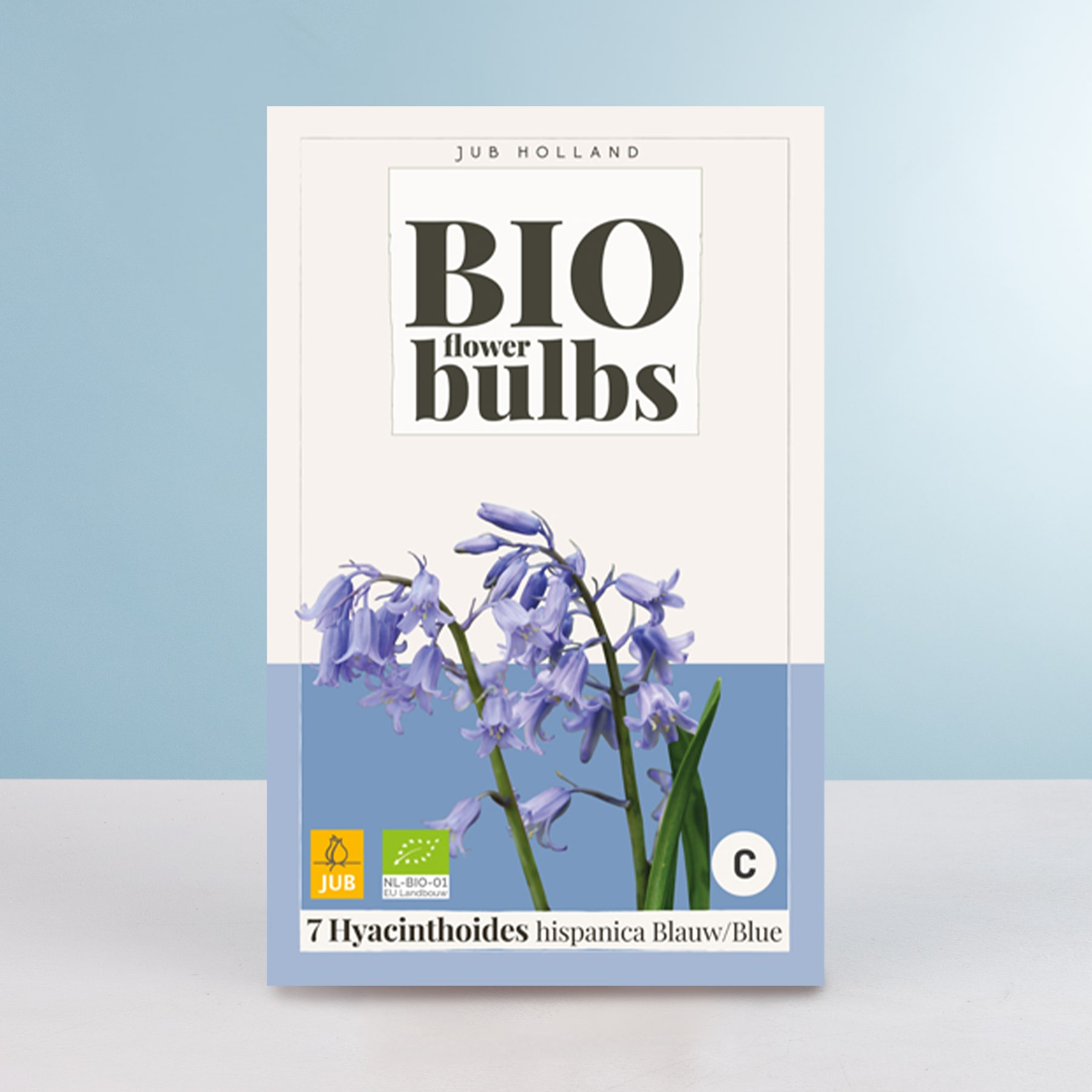 Das Bild zeigt eine Schachtel Bio-Blumenzwiebeln und eine Nahaufnahme mehrerer violetter Hyazinthenblüten vor einem hellblauen Hintergrund.