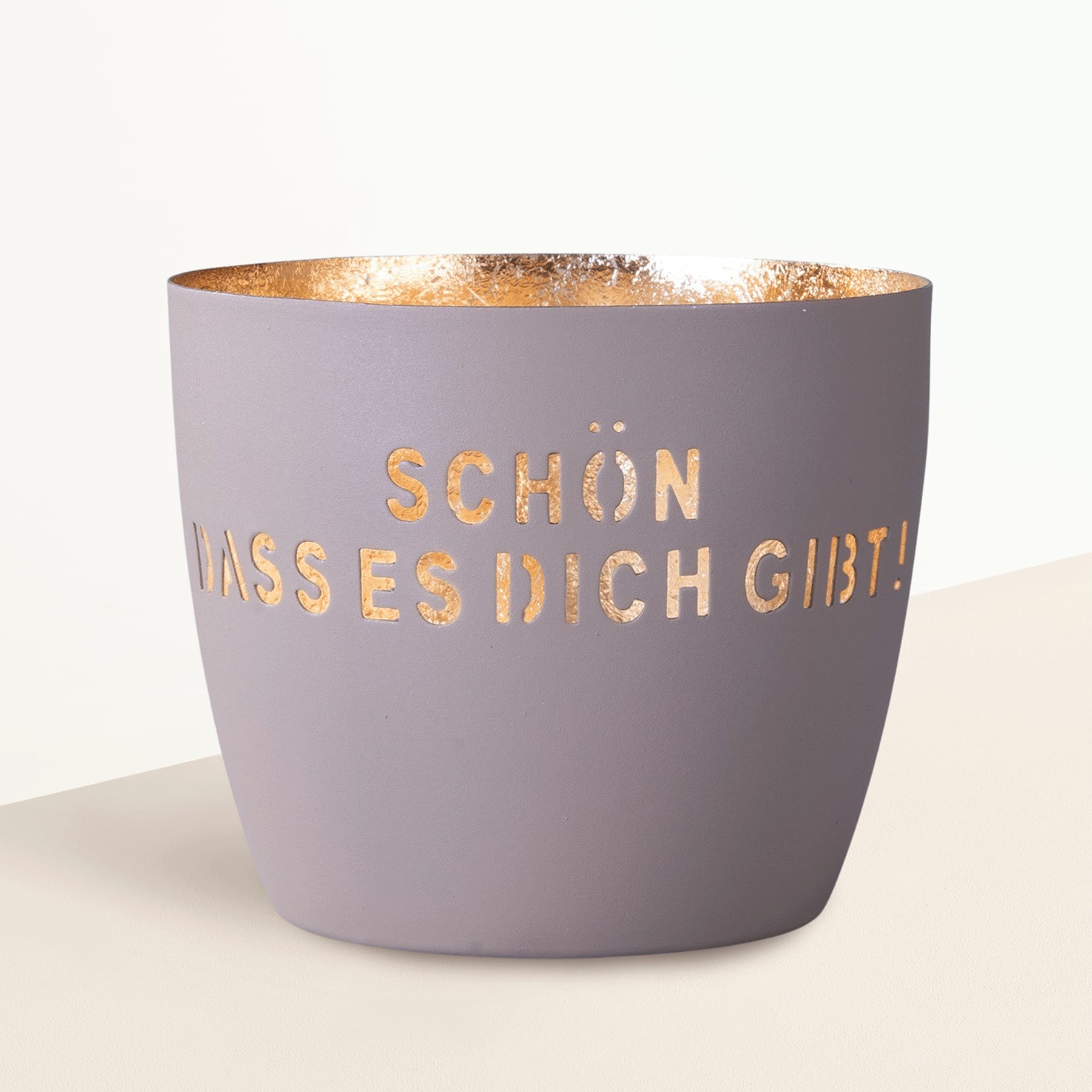 Ein grauer Keramiktopf mit dem Aufdruck „Schön, dass es dich gibt“ steht auf einer Holzoberfläche.