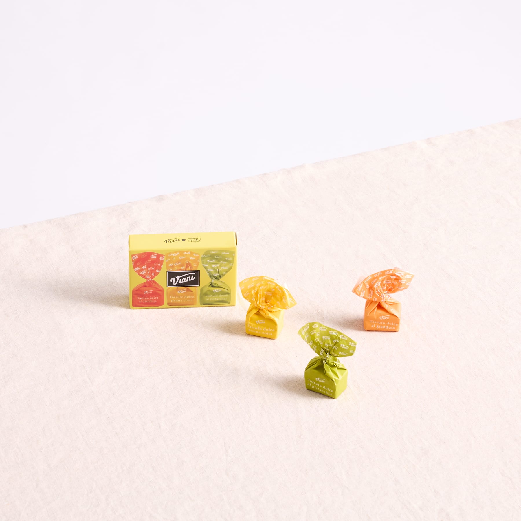 Das Bild zeigt verschiedene bunte Bonbons oder Süßigkeiten, die auf einem schlichten weißen Hintergrund angeordnet sind.