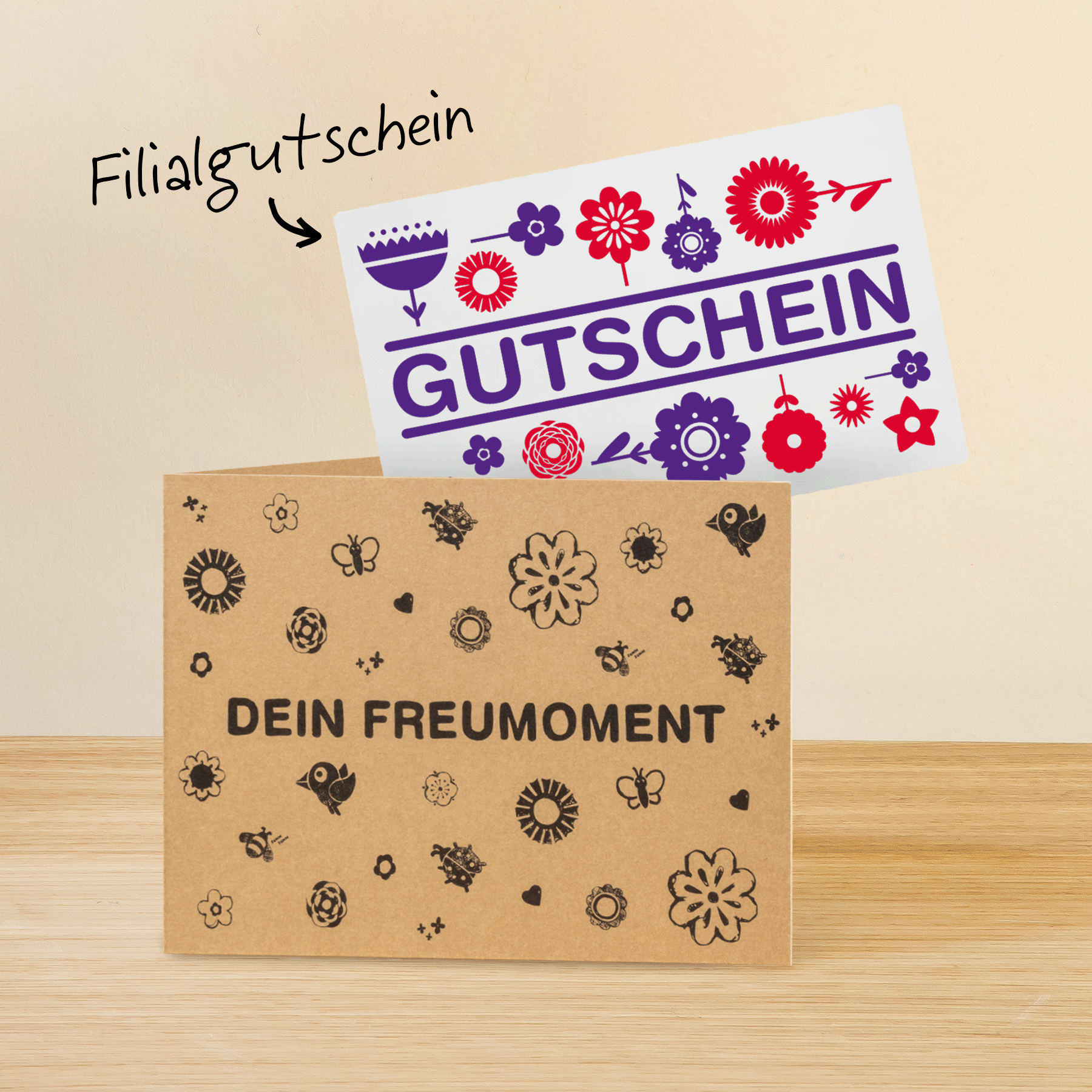 Das Bild zeigt einen Geschenkgutschein mit farbenfrohen Blumenmotiven und dem deutlich sichtbaren Wort „Gutschein“. Der Hintergrund des Bildes ist eine Holzoberfläche.