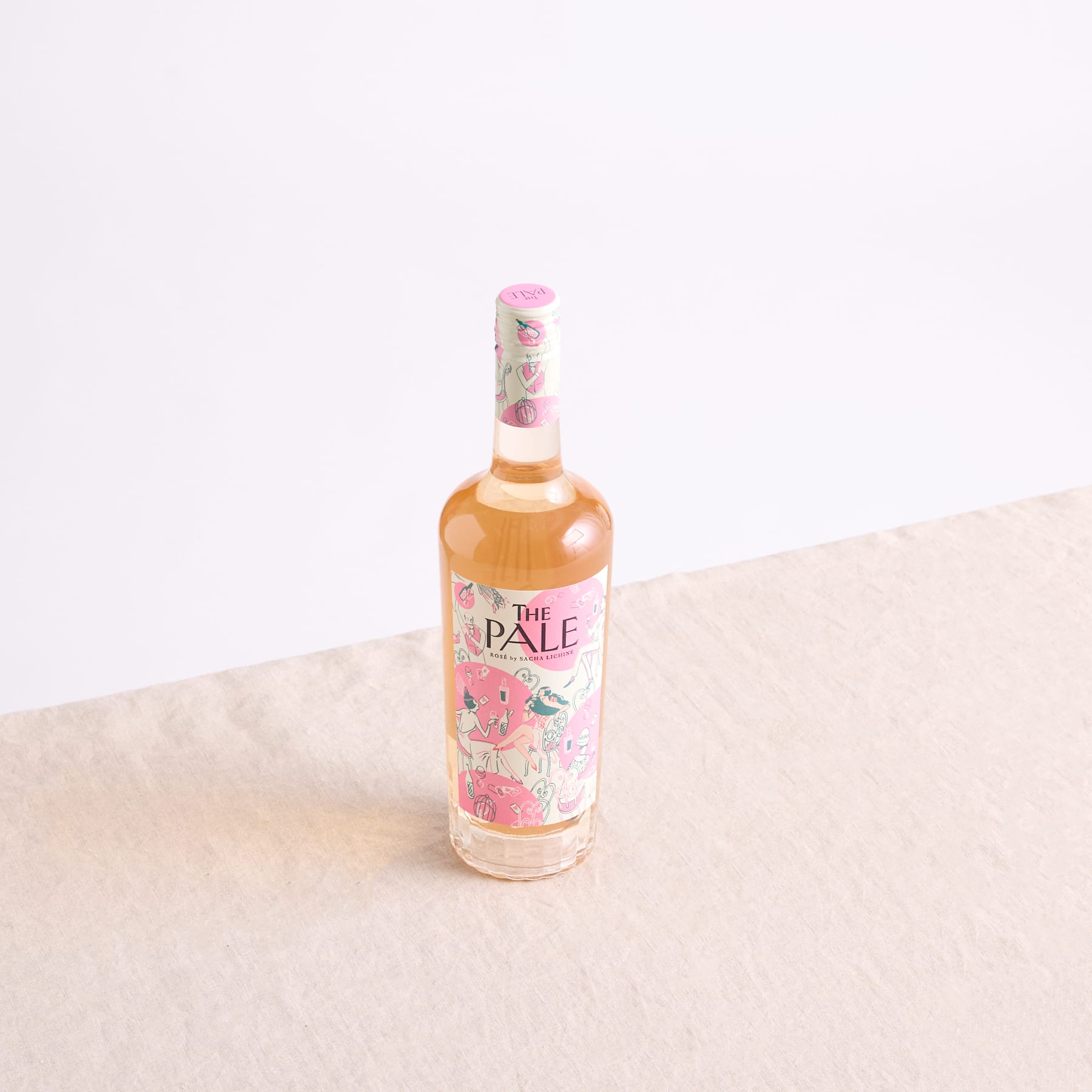 Eine Flasche Pale Ale mit einem Blumenetikett steht auf einer hellen Fläche vor einem schlichten Hintergrund.