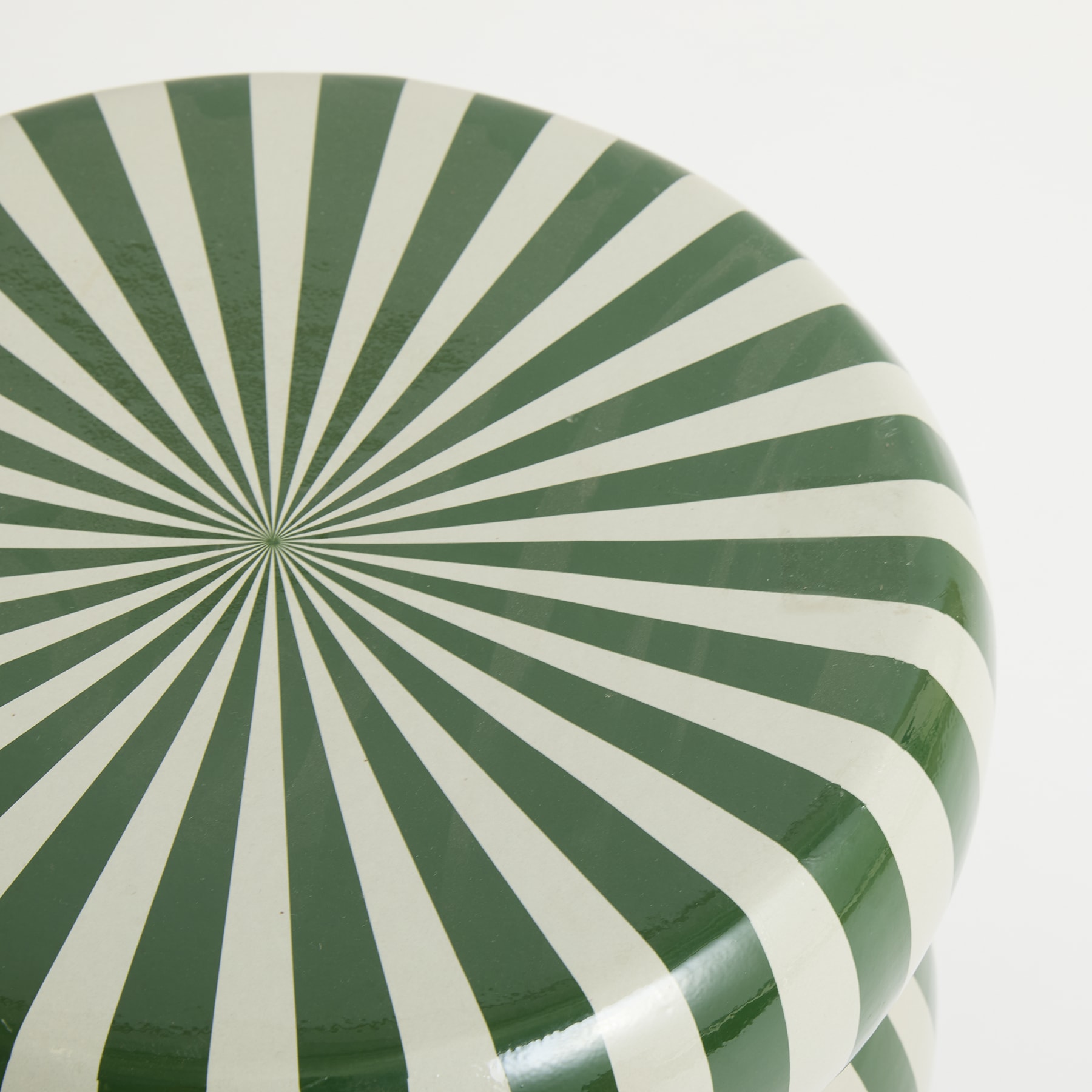 Das Bild zeigt ein kreisförmiges Muster aus abwechselnd grünen und weißen radialen Streifen, wodurch eine eindrucksvolle optische Illusion von Tiefe und Bewegung entsteht.