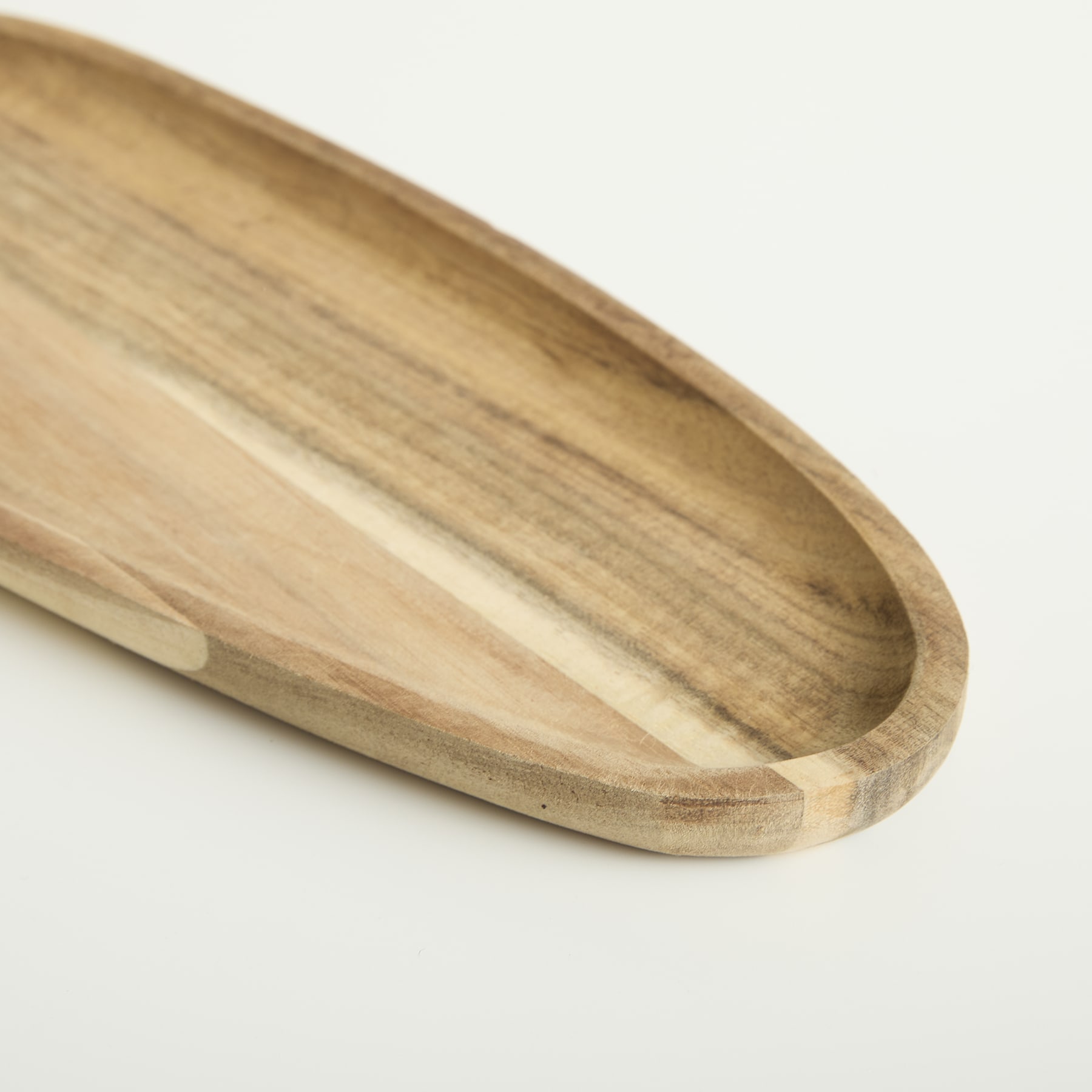 Ein Serviertablett oder eine Servierplatte aus Holz mit einer geschwungenen, länglichen Form und einer glatten, natürlichen Maserung vor einem schlichten, hellen Hintergrund.