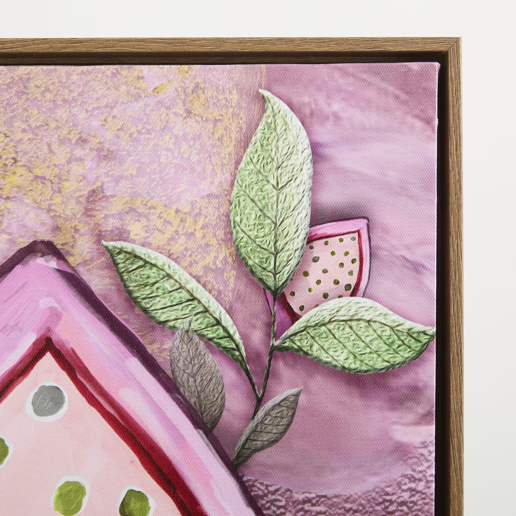 Ein gerahmtes Kunstwerk mit einem leuchtend rosa und violetten Hintergrund und einem grünen blattähnlichen Element im Vordergrund.
