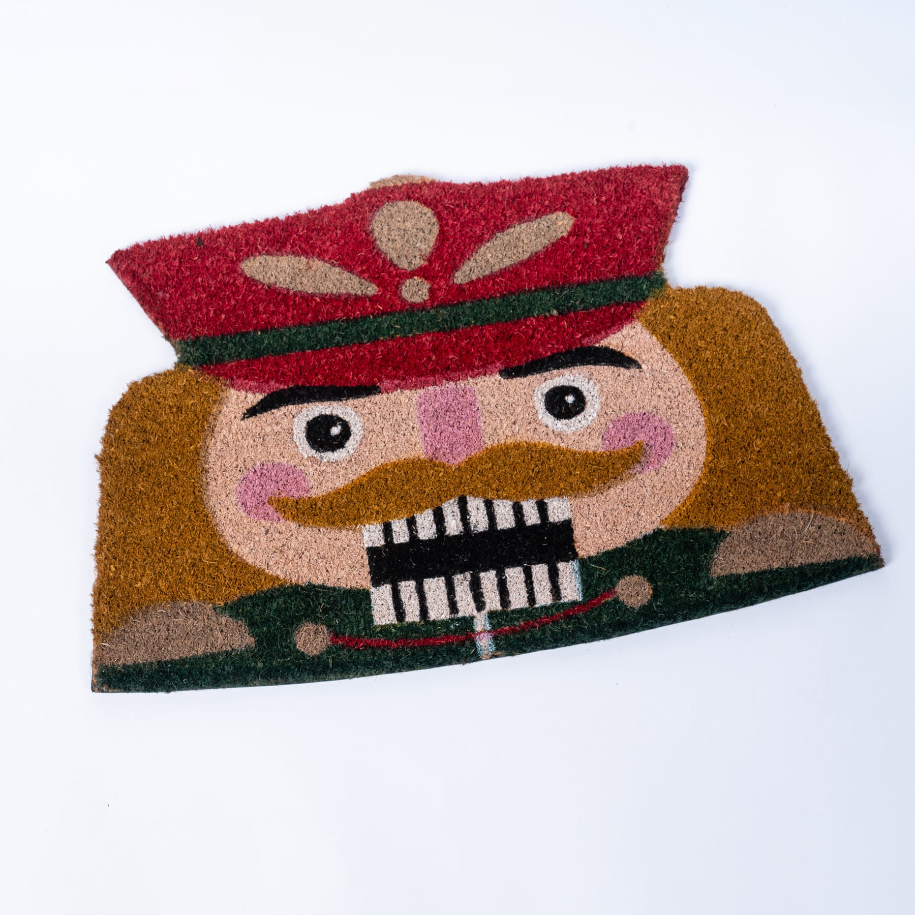 Eine farbenfrohe, strukturierte Fußmatte mit einer Comicfigur mit roter Mütze und Uniform und einem Zug oder einer Lokomotive im Hintergrund.