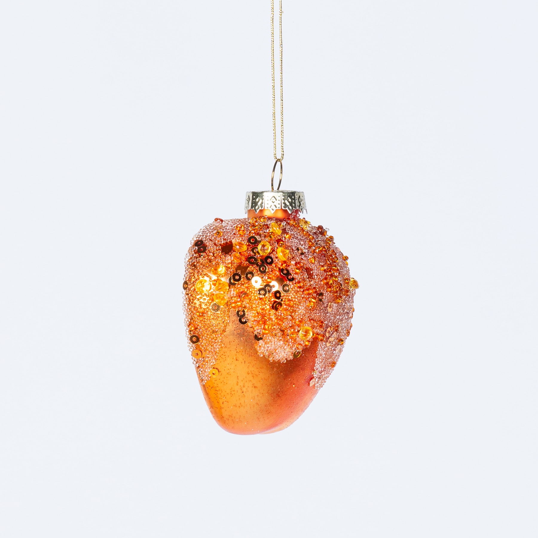 Ein leuchtendes, glitzerndes Glasornament in Form einer Eichel, das vor einem schlichten weißen Hintergrund schwebt.