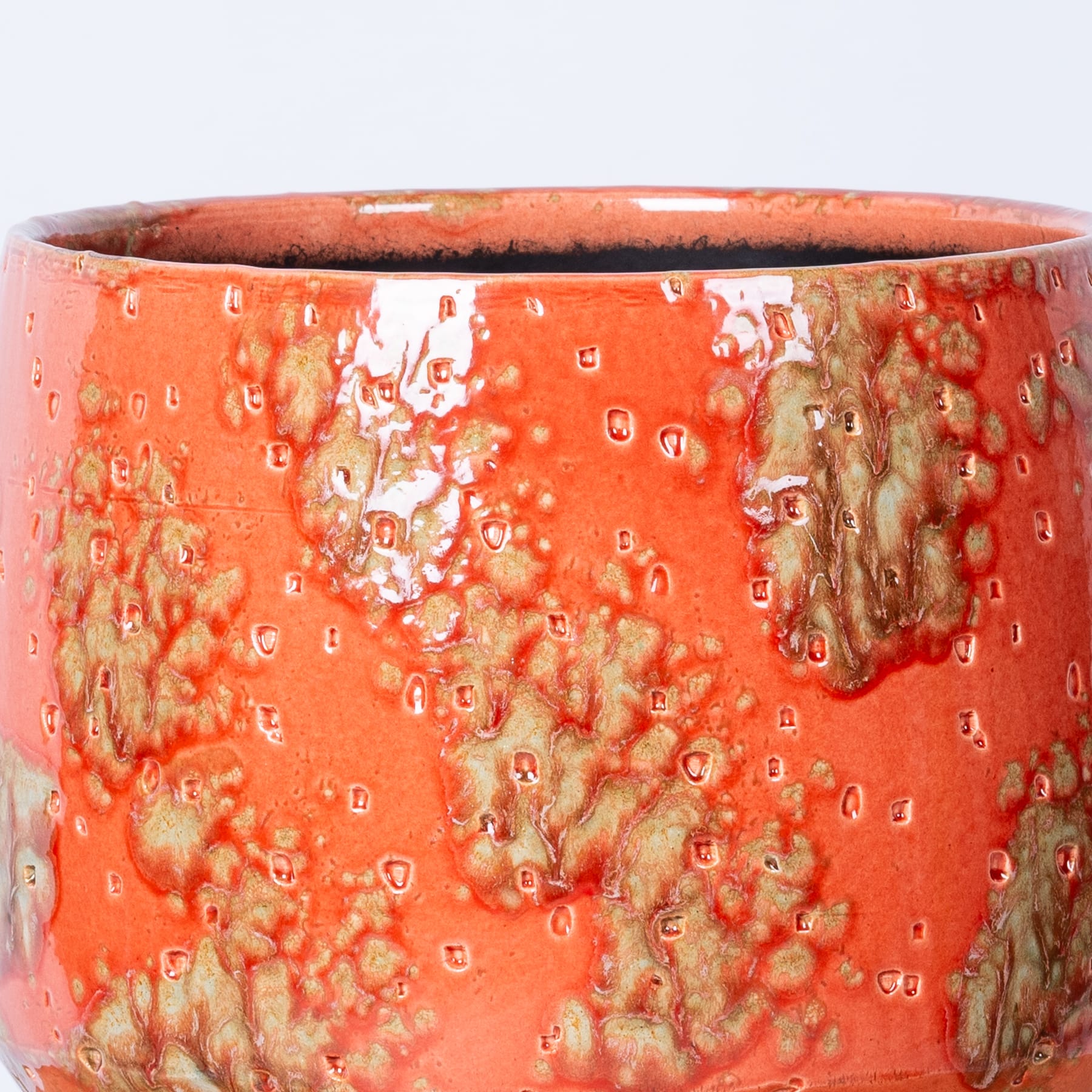 Ein lebendiges, strukturiertes Keramikgefäß mit einer auffälligen orangeroten Glasur und komplizierten Mustern sowie Variationen in Farbe und Struktur auf der gesamten Oberfläche.