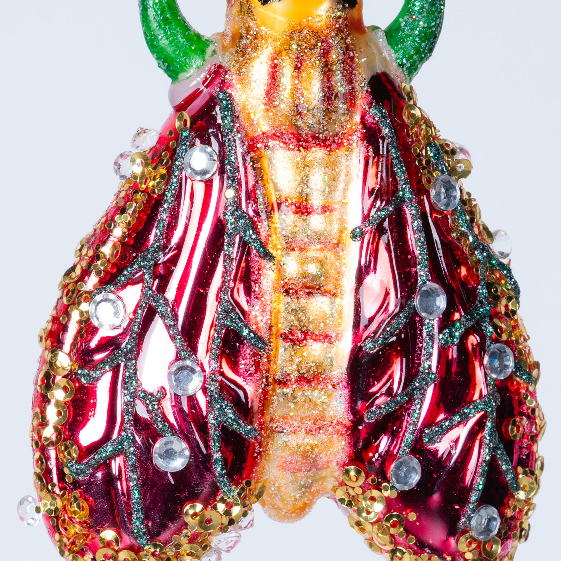 Eine lebendige und komplexe insektenähnliche Kreatur, geschmückt mit einer Reihe farbenfroher, strukturierter Elemente vor einem schlichten weißen Hintergrund.