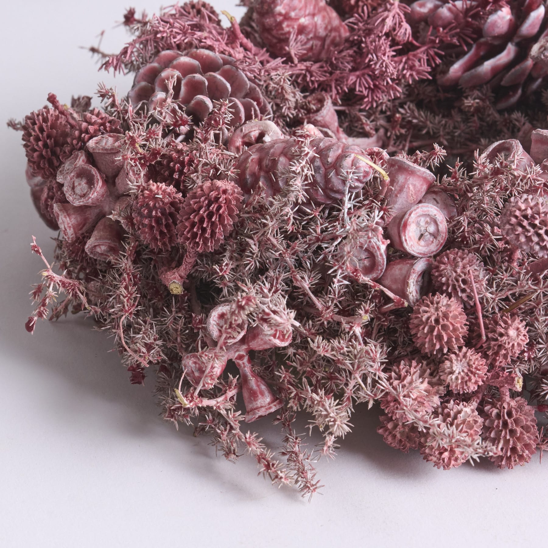Ein farbenfroher Strauß aus Blumen in verschiedenen Rosa- und Lilatönen, darunter Rosen, Chrysanthemen und andere zarte Blüten, füllt den Rahmen vor einem neutralen Hintergrund.