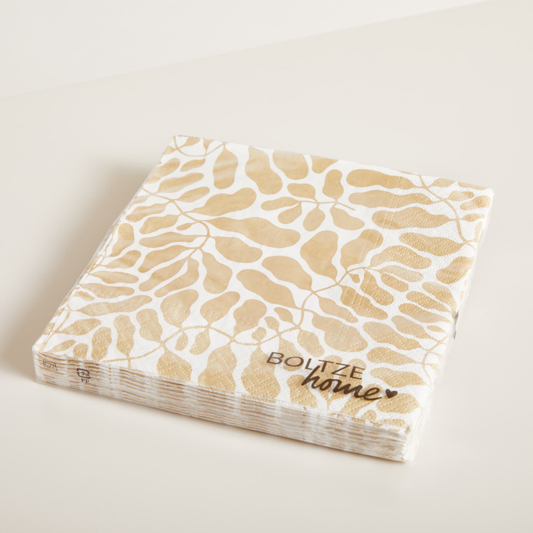 Ein Stapel quadratischer Papierservietten mit einem beige-weißen Giraffenmuster auf einem schlichten, hellen Hintergrund.