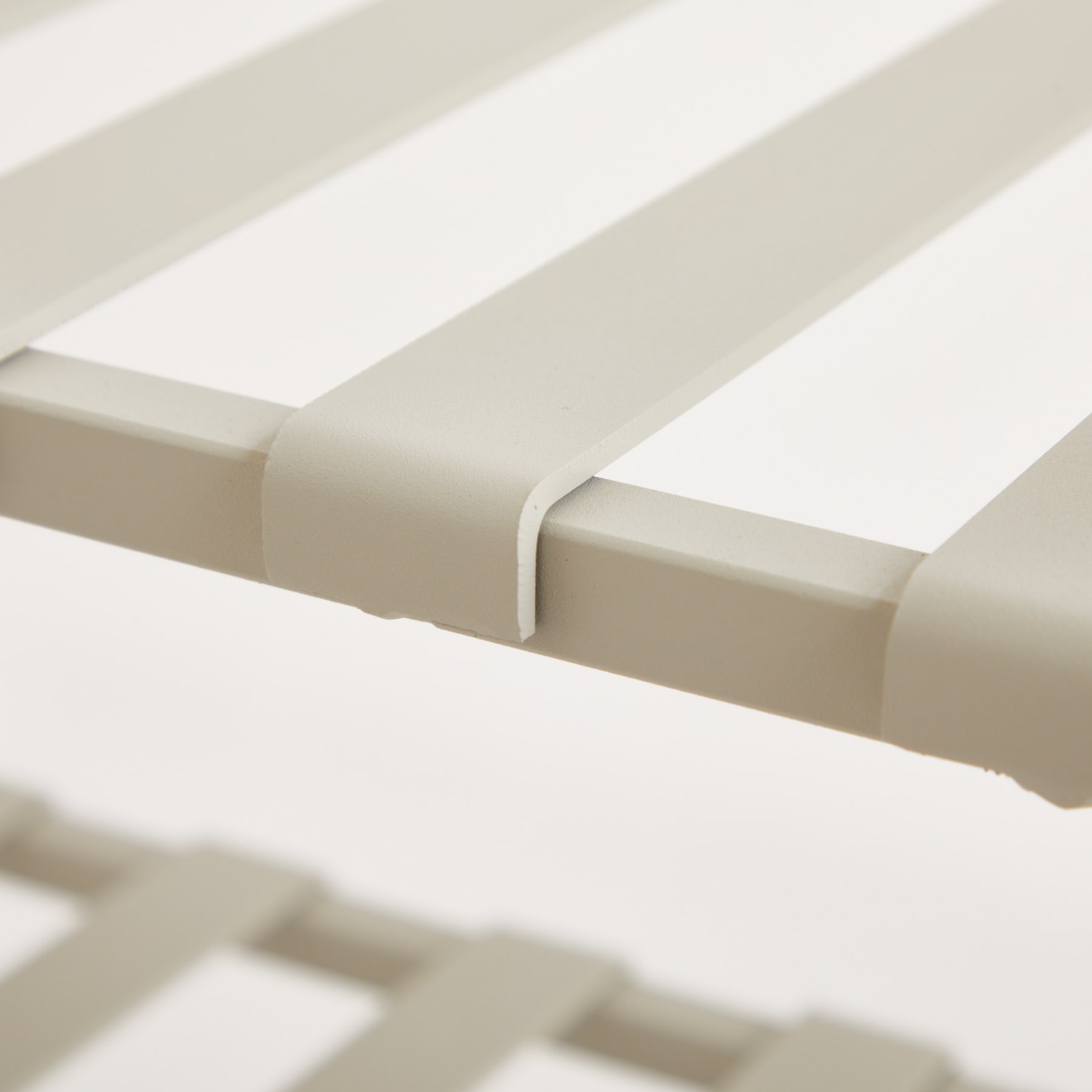 Das Bild zeigt einen weißen, minimalistischen Tisch oder ein Regal mit klaren, geometrischen Linien und einem einfachen, eleganten Design.