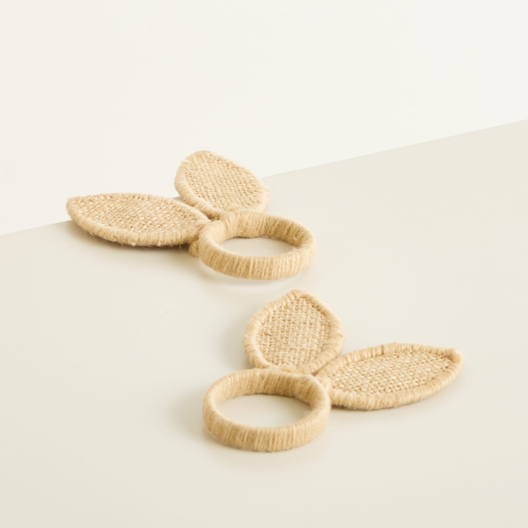 Das Bild zeigt mehrere beige, gewebte Scheiben oder Ringe, die auf einer hellen Oberfläche angeordnet sind.