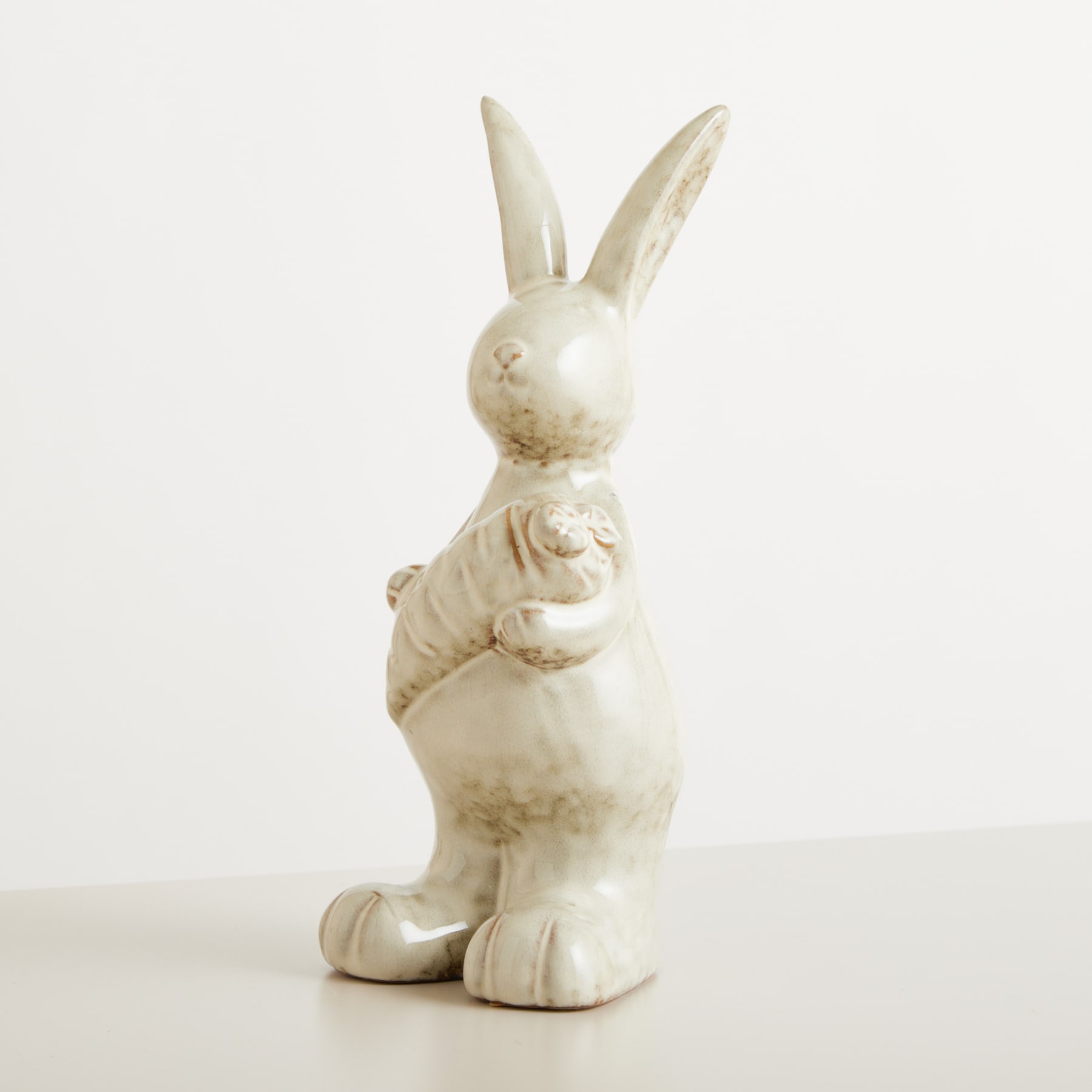 Eine weiße Keramikfigur eines stehenden Kaninchens mit langen Ohren und rundem Körper vor einem schlichten weißen Hintergrund.