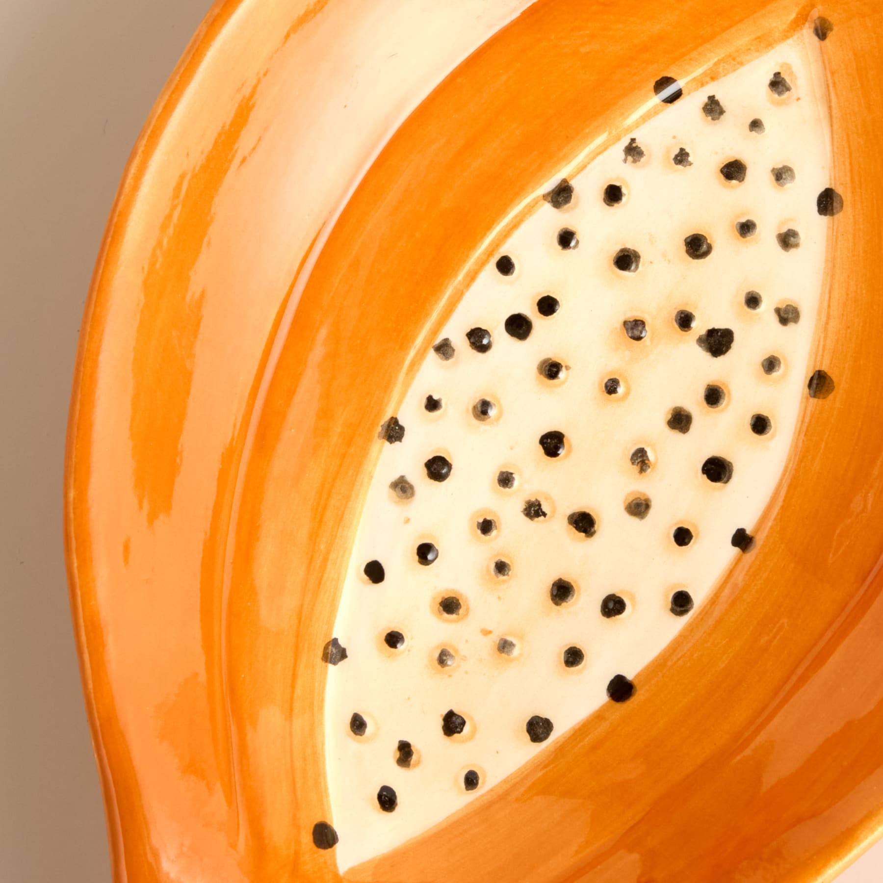 Eine leuchtend orangefarbene Papayafrucht mit sichtbaren schwarzen Kernen auf dem freiliegenden Fruchtfleisch.