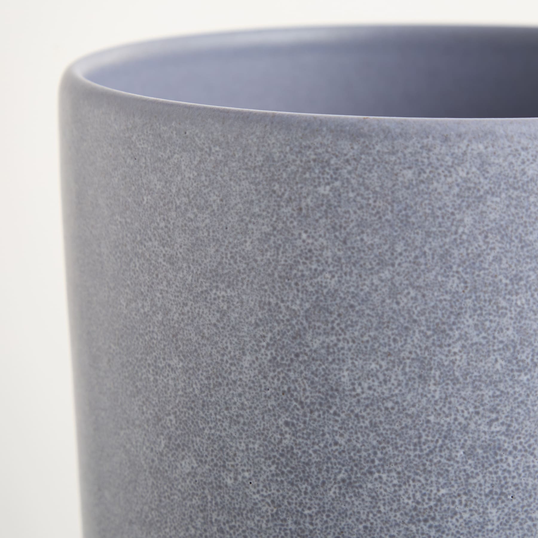 Eine Nahaufnahme eines grauen Keramik- oder Porzellanbehälters mit strukturierter, matter Oberfläche.