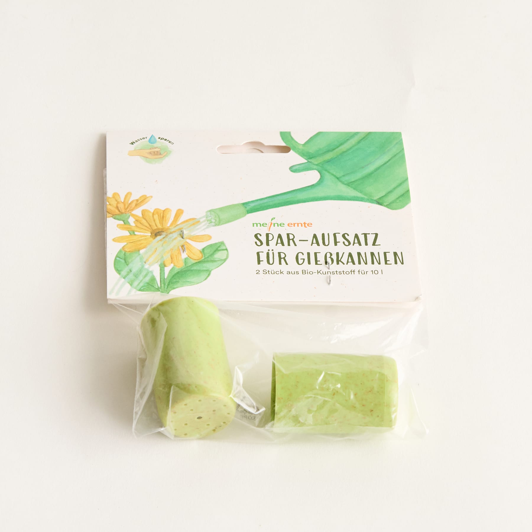 Das Bild zeigt einen grünen Salzstreuer und eine Packung grünes Badesalz mit einem Blumenmuster auf der Verpackung.