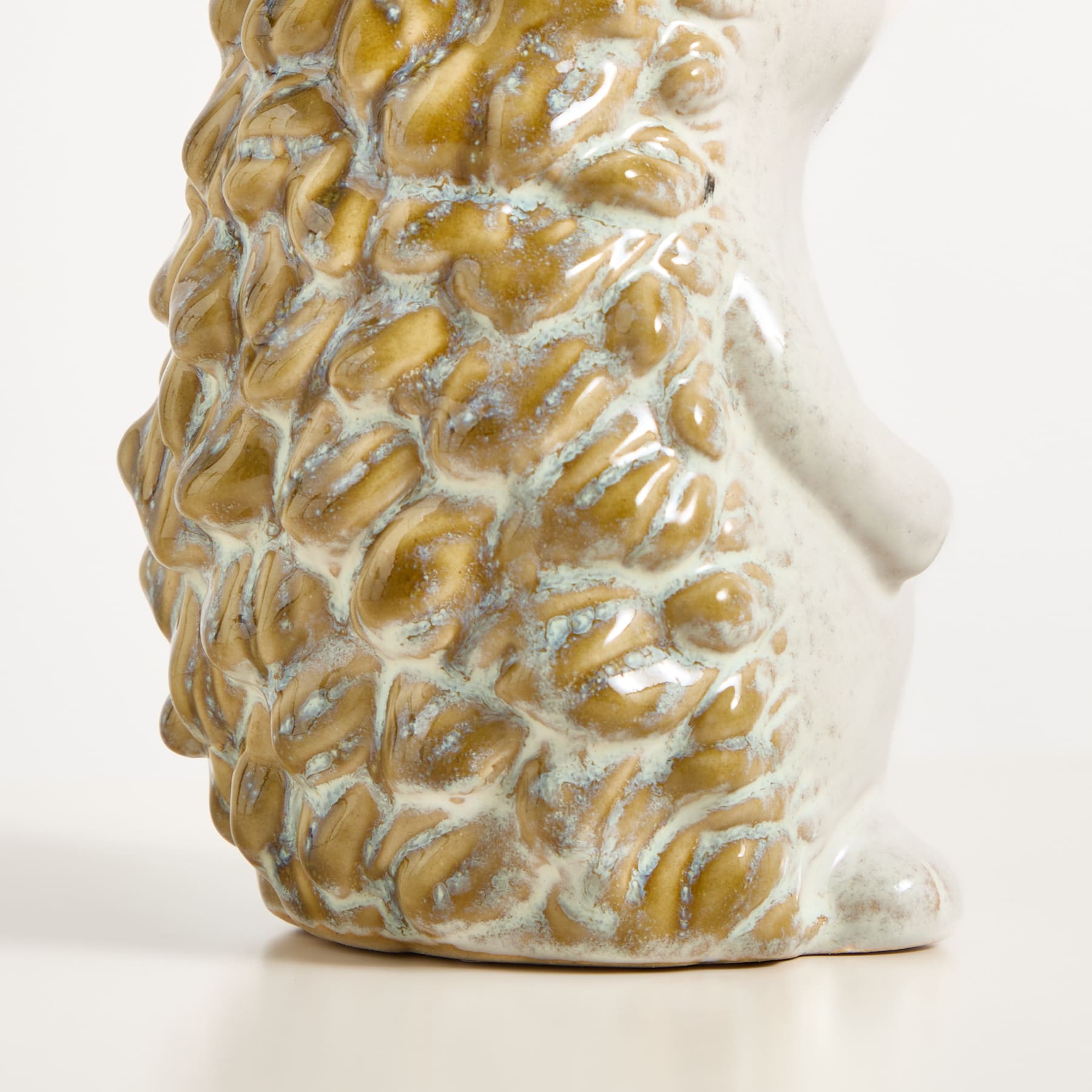 Eine Nahaufnahme einer Ananas, die ihre komplexe und strukturierte Schale vor einem schlichten weißen Hintergrund zeigt.
