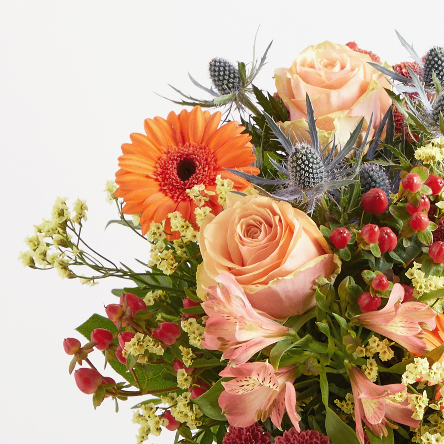 Ein farbenfroher Strauß verschiedener Blumen, darunter orangefarbene Gerbera, pfirsichfarbene Rosen und andere bunte Blüten, arrangiert vor einem schlichten weißen Hintergrund.