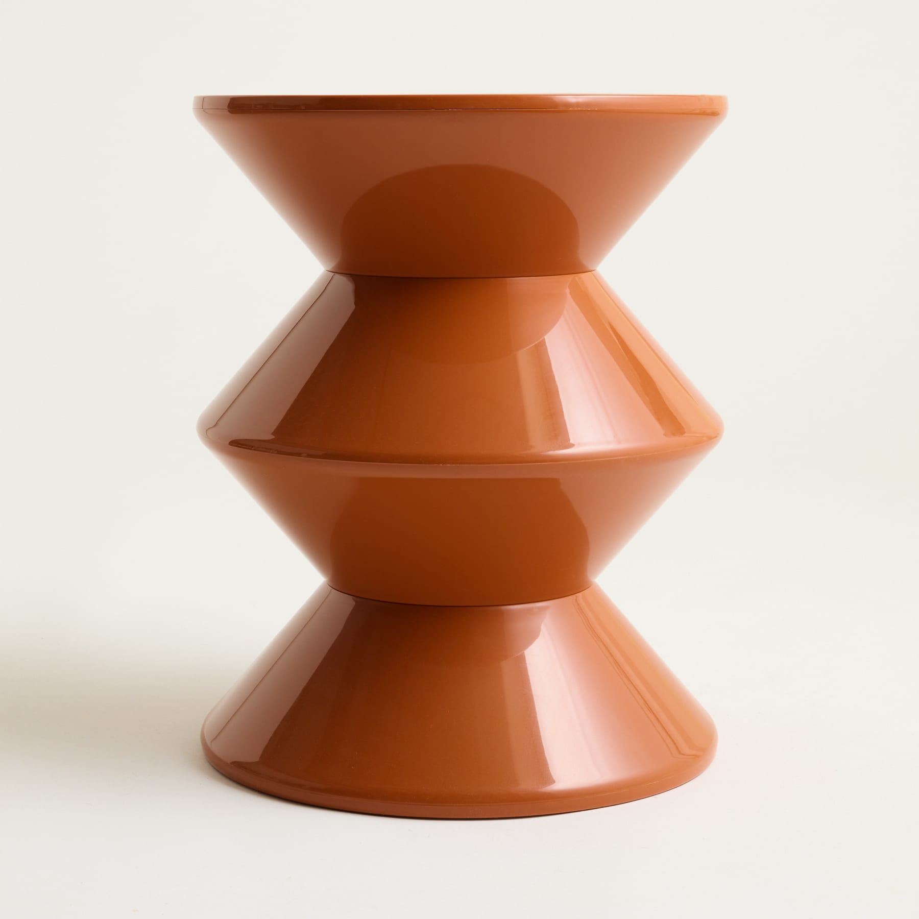 Ein Stapel aus drei terrakottafarbenen Keramikschalen oder -tassen, angeordnet in einem symmetrischen und minimalistischen Design vor einem schlichten weißen Hintergrund.