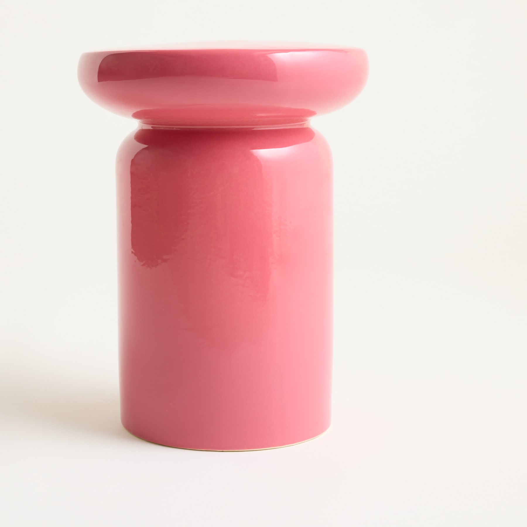 Ein leuchtend rosa Keramikbehälter mit abgerundeter Form und flacher Oberseite steht vor einem schlichten weißen Hintergrund.