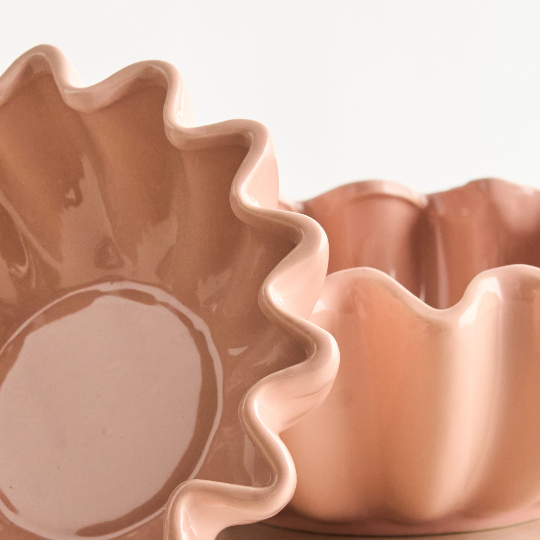 Eine Nahaufnahme einer leuchtend gelben, welligen und strukturierten Oberfläche, wahrscheinlich ein Stück Stoff oder Material, das den Rahmen mit seiner auffälligen Farbe und organischen, wellenförmigen Form ausfüllt.