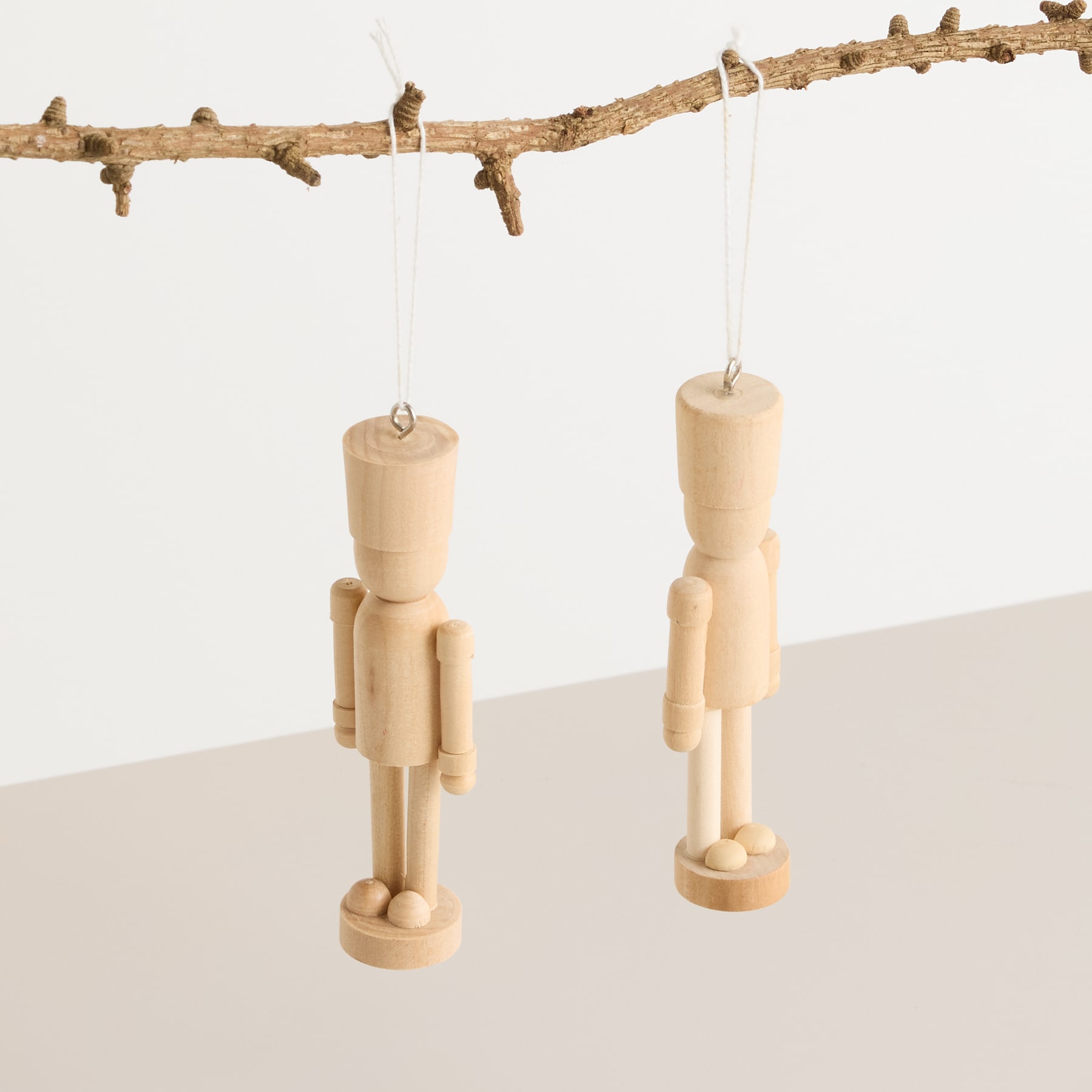 Eine hölzerne Nussknackerfigur hängt vor einem schlichten weißen Hintergrund.
