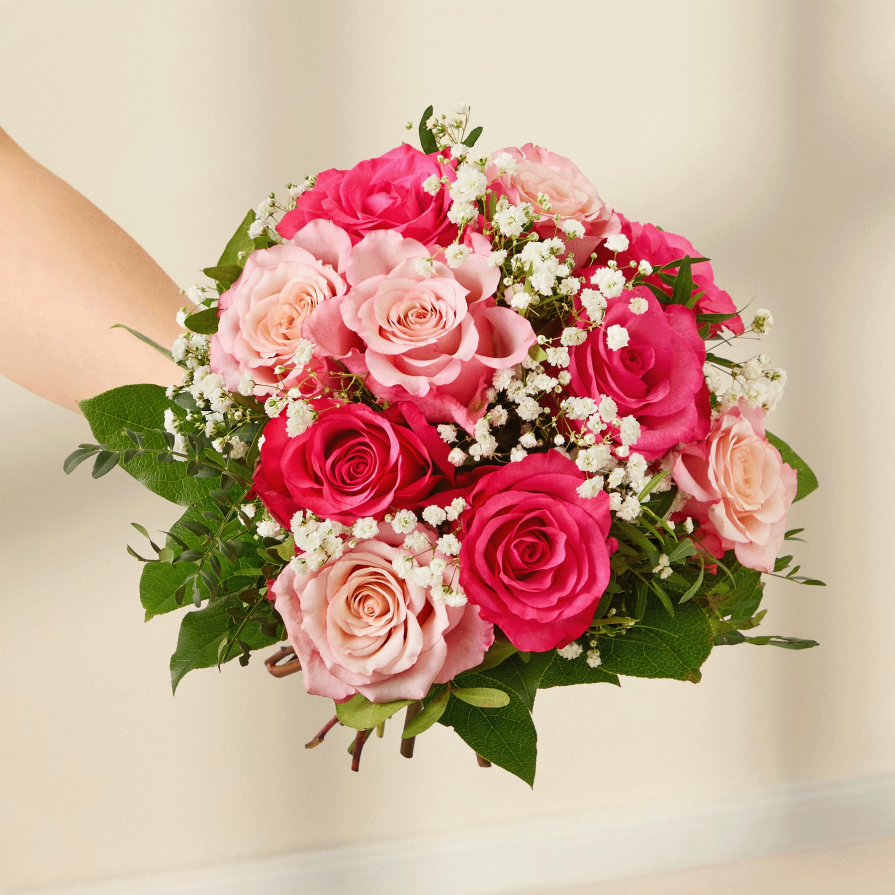 Ein lebendiger Strauß roter und rosa Rosen, umgeben von zarten weißen Blüten, die ein optisch beeindruckendes und harmonisches Arrangement ergeben.