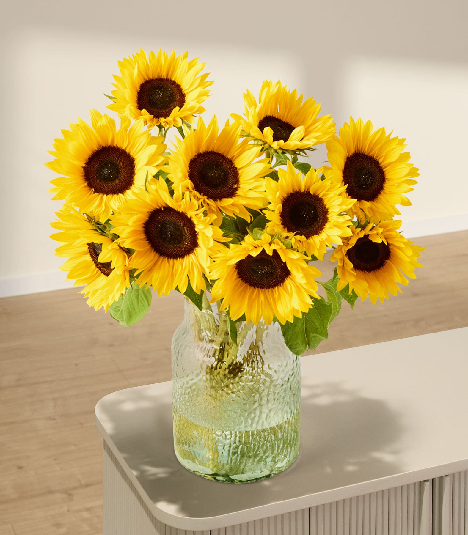 Ein lebendiger Strauß leuchtend gelber Sonnenblumen, den eine Person vor einem hellblauen Hintergrund in der Hand hält.