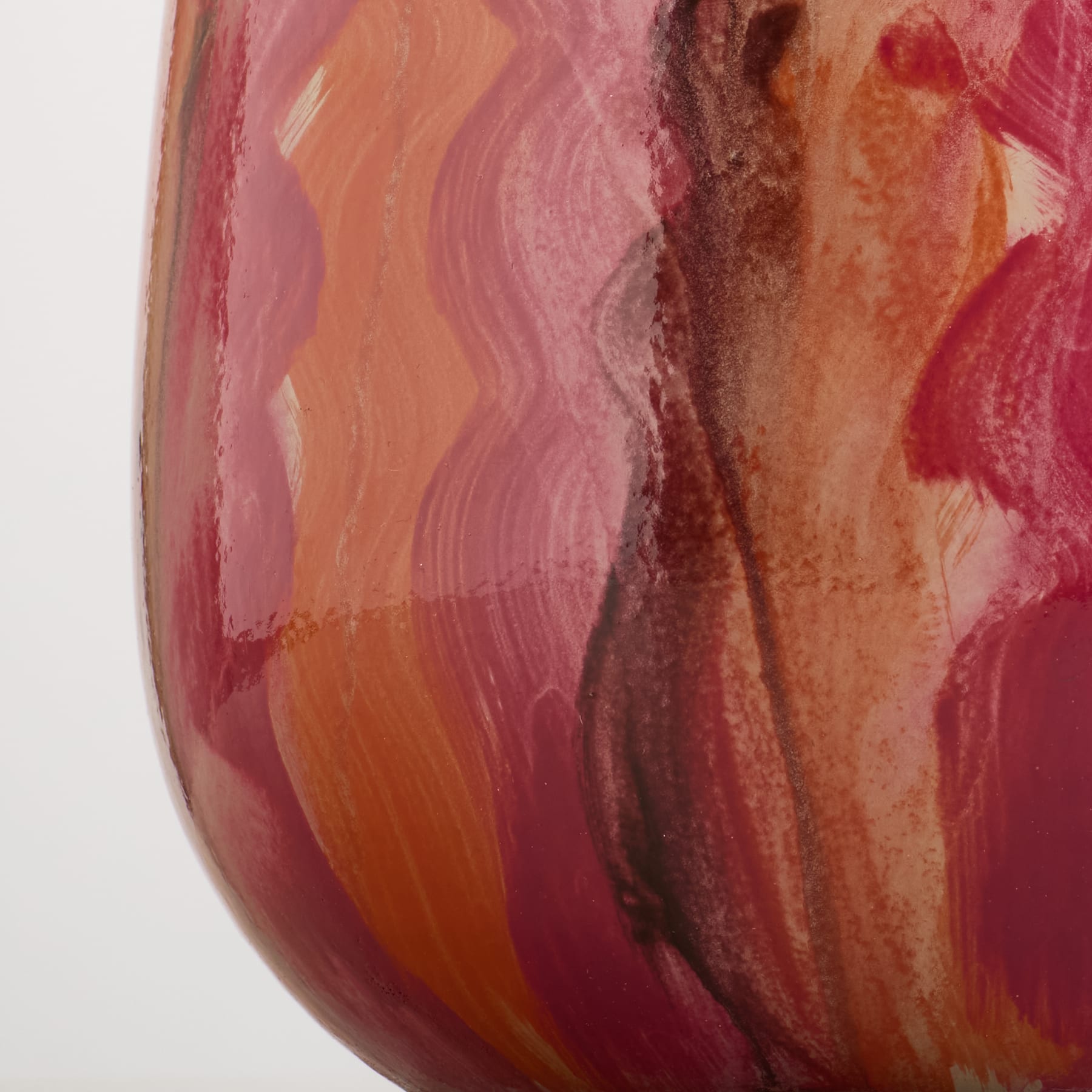 Eine Nahaufnahme einer Vase mit wirbelnden rosa, orangen und braunen Pinselstrichen füllt den Vordergrund vor einem schlichten weißen Hintergrund.