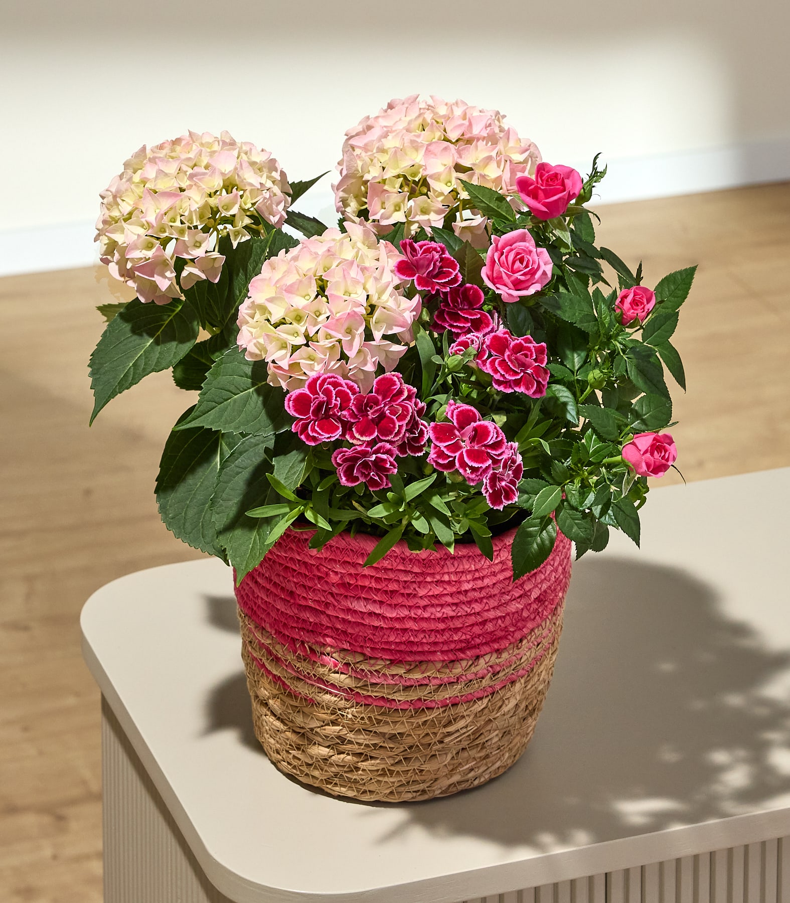 Ein leuchtender Strauß aus rosa Hortensien und Rosen vor hellem Hintergrund ergibt ein wunderschönes und farbenfrohes Blumenarrangement.