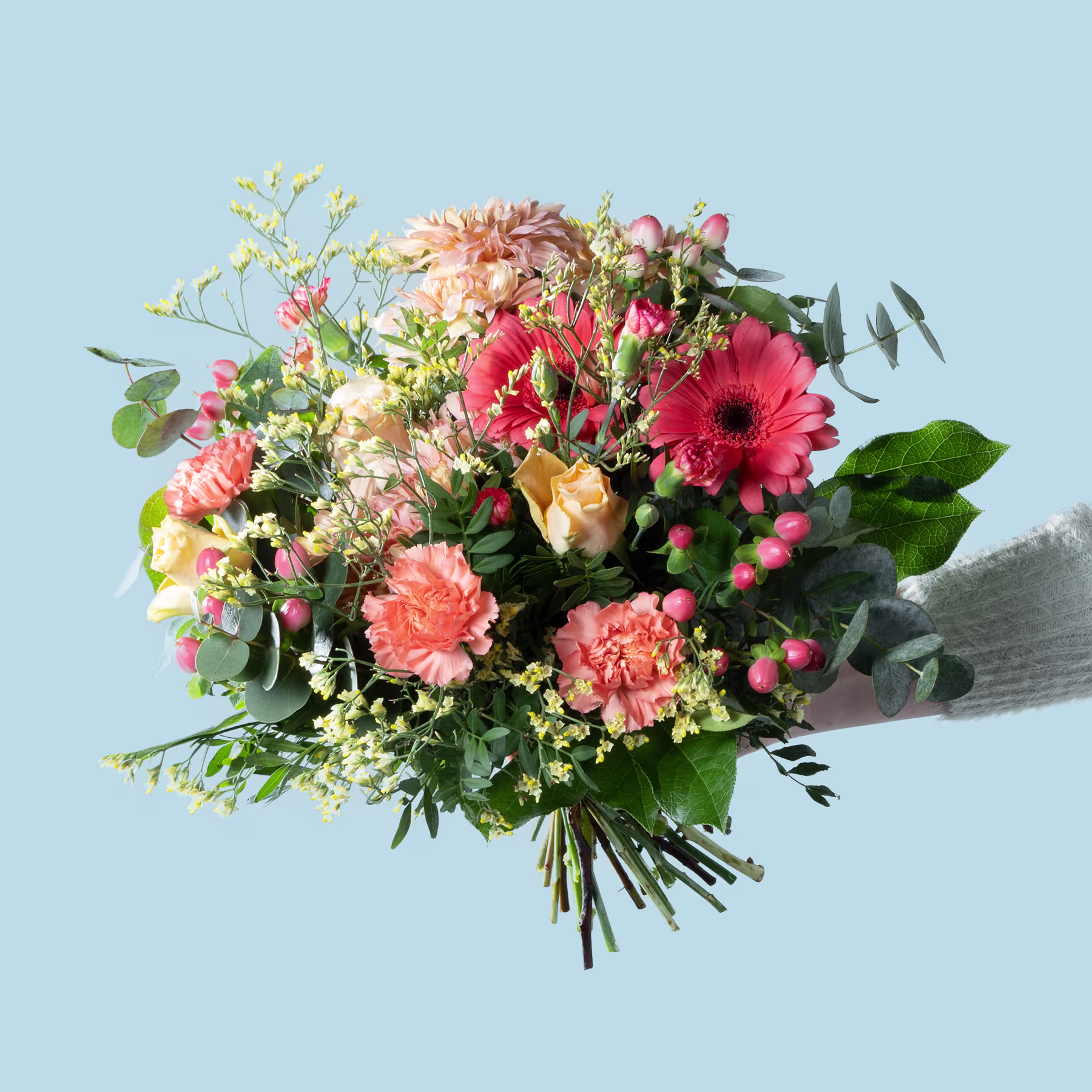 Ein lebendiger Strauß bunter Blumen, darunter Gerbera, Rosen und andere Blüten, steht vor dem Hintergrund eines ruhigen blauen Himmels. (Beschreibungstext KI-generiert)