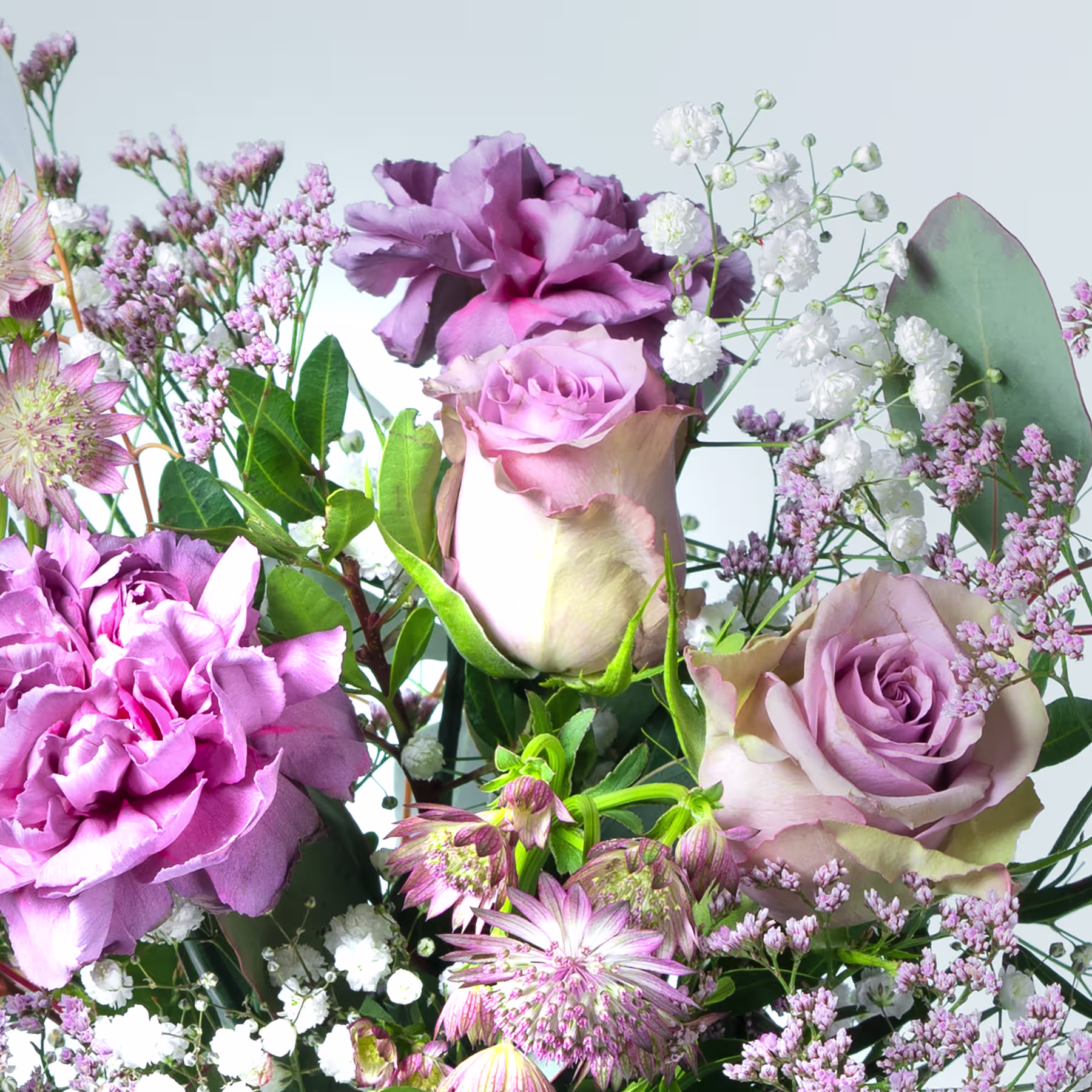 Ein lebendiger Strauß verschiedener rosa und violetter Blumen, darunter Rosen, Pfingstrosen und Schleierkraut, vor einem weichen, unscharfen Hintergrund. (Beschreibungstext KI-generiert)