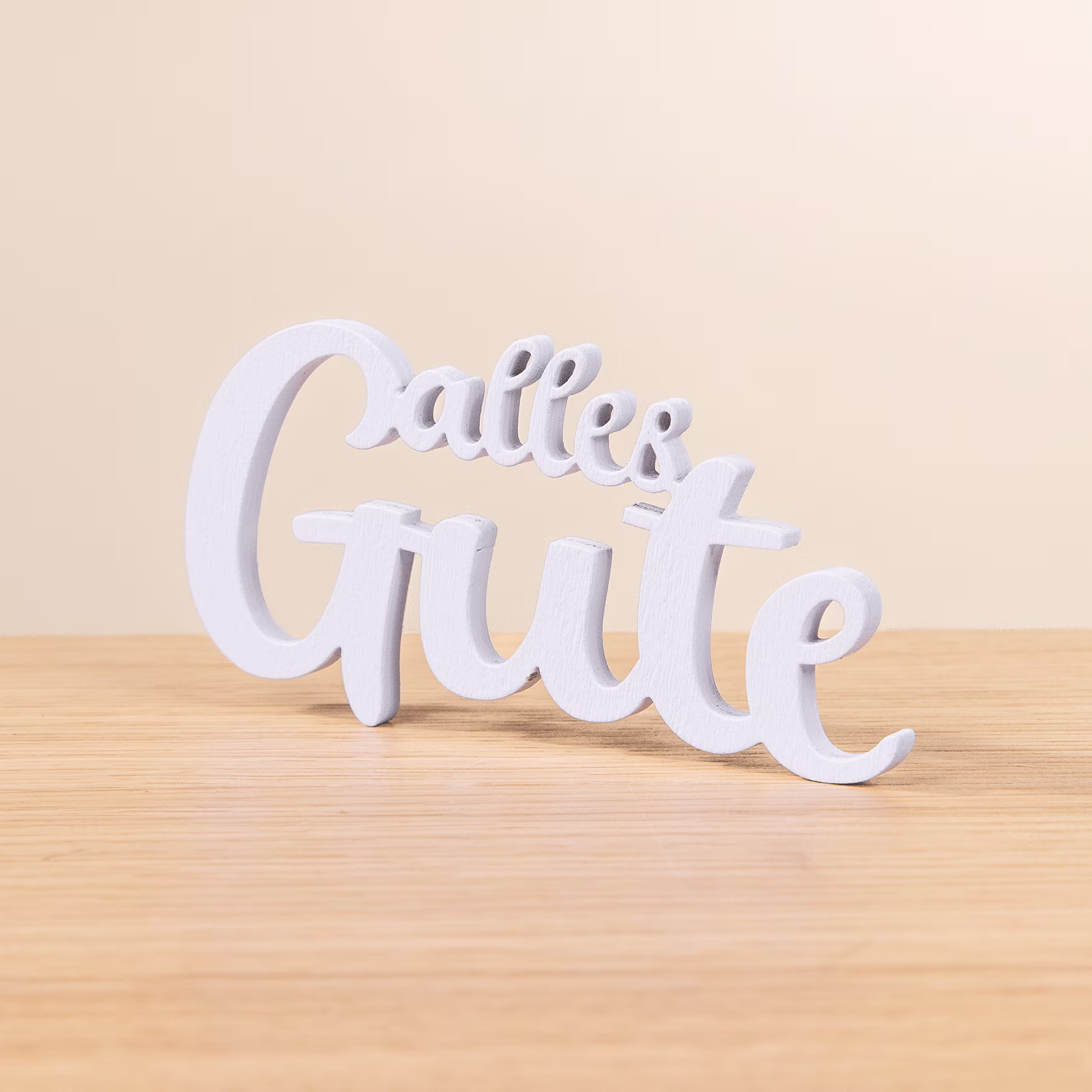 Das Bild zeigt den Schriftzug „Glutenfrei“ in weißen Buchstaben auf einer Holzoberfläche vor hellem Hintergrund. (Beschreibungstext KI-generiert)
