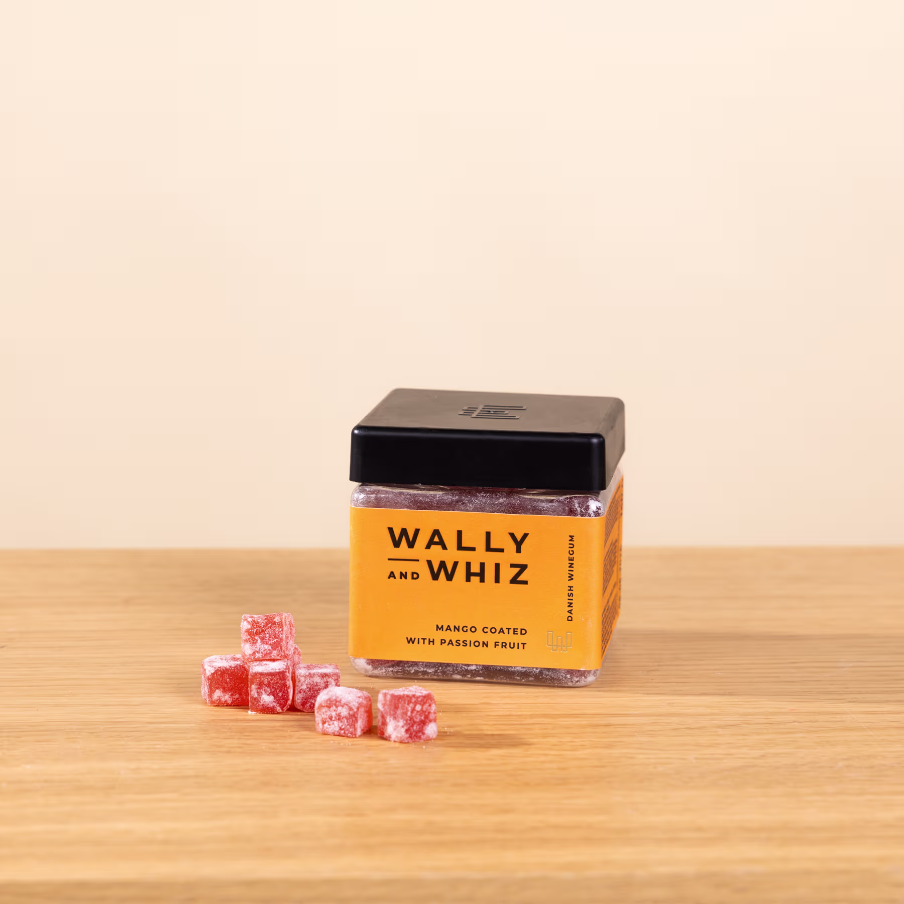 Ein Holztisch mit einer Schachtel Wally- und Whiz-Bonbons und mehreren Bonbonstücken, die auf der Oberfläche verstreut sind. (Beschreibungstext KI-generiert)