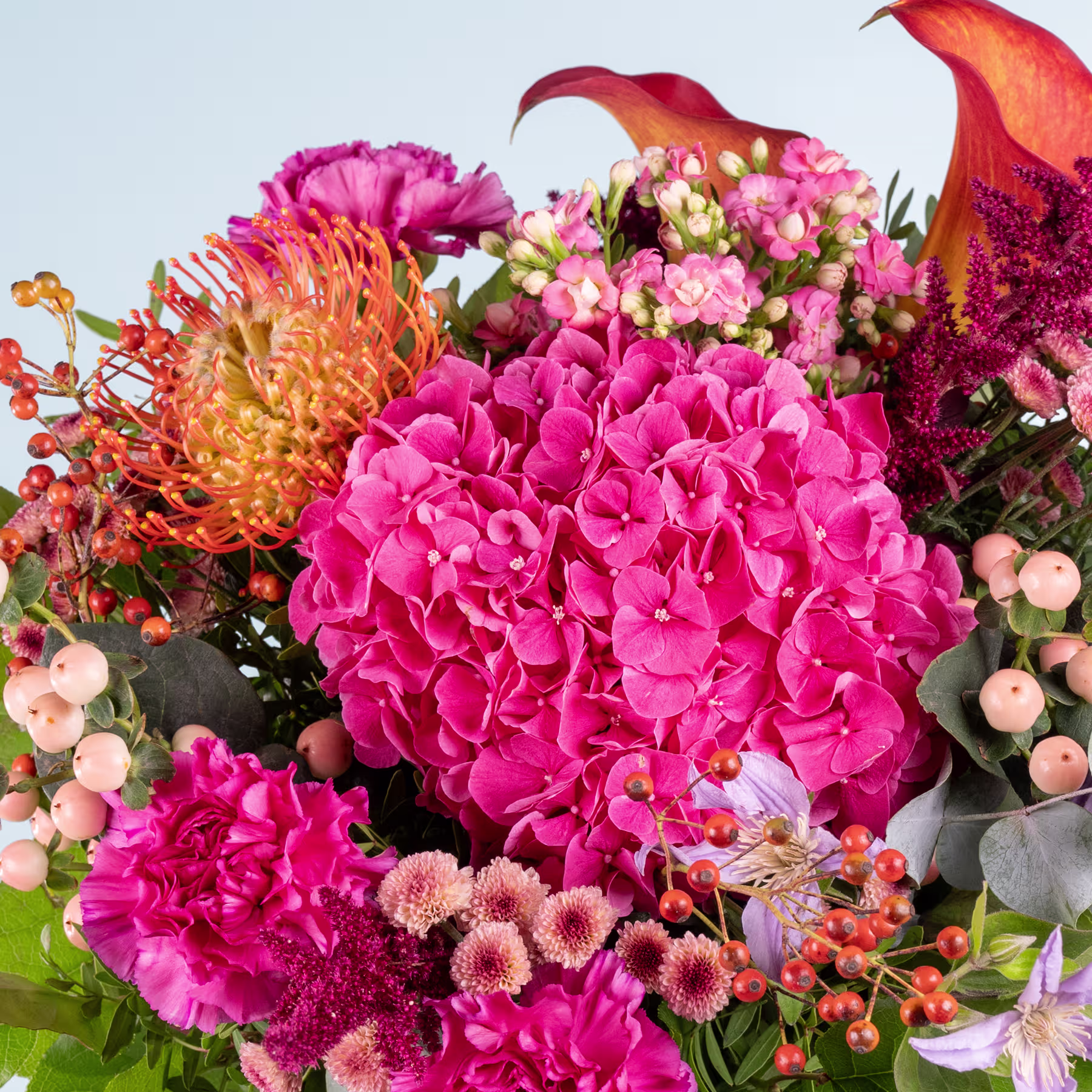 Ein leuchtender Strauß aus rosa Hortensien, orangefarbenen Chrysanthemen und anderen bunten Blumen vor einem klaren blauen Himmel. (Beschreibungstext KI-generiert)