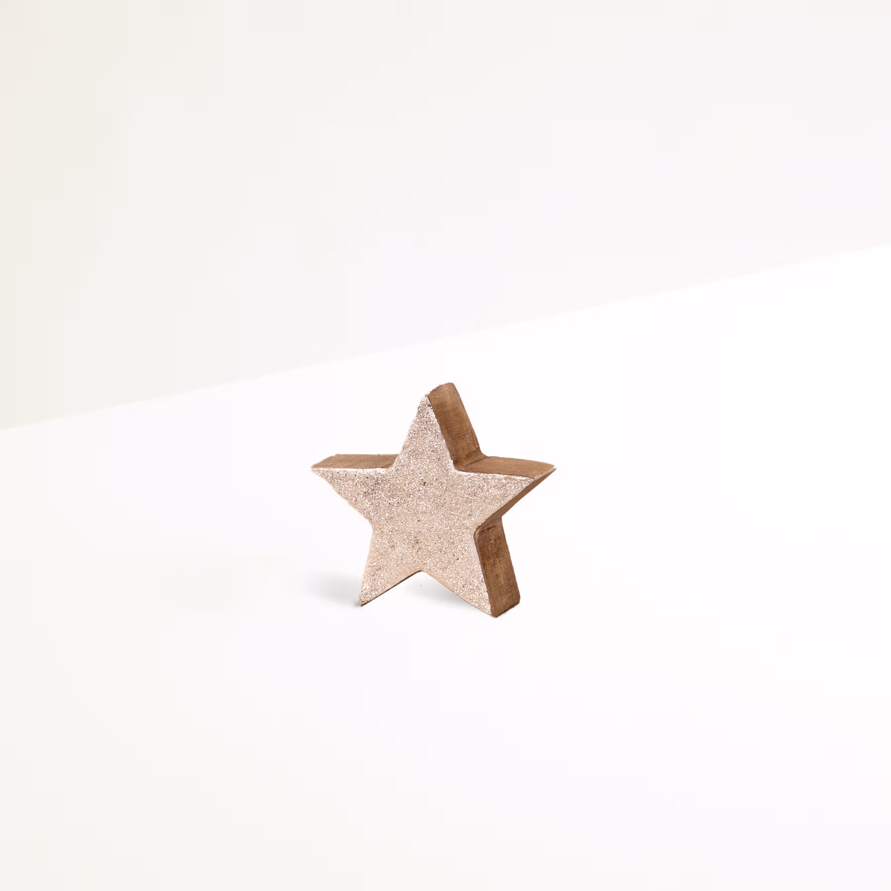 Ein einfaches, sternförmiges Holzobjekt befindet sich auf einem schlichten, weißen Hintergrund. (Beschreibungstext KI-generiert)