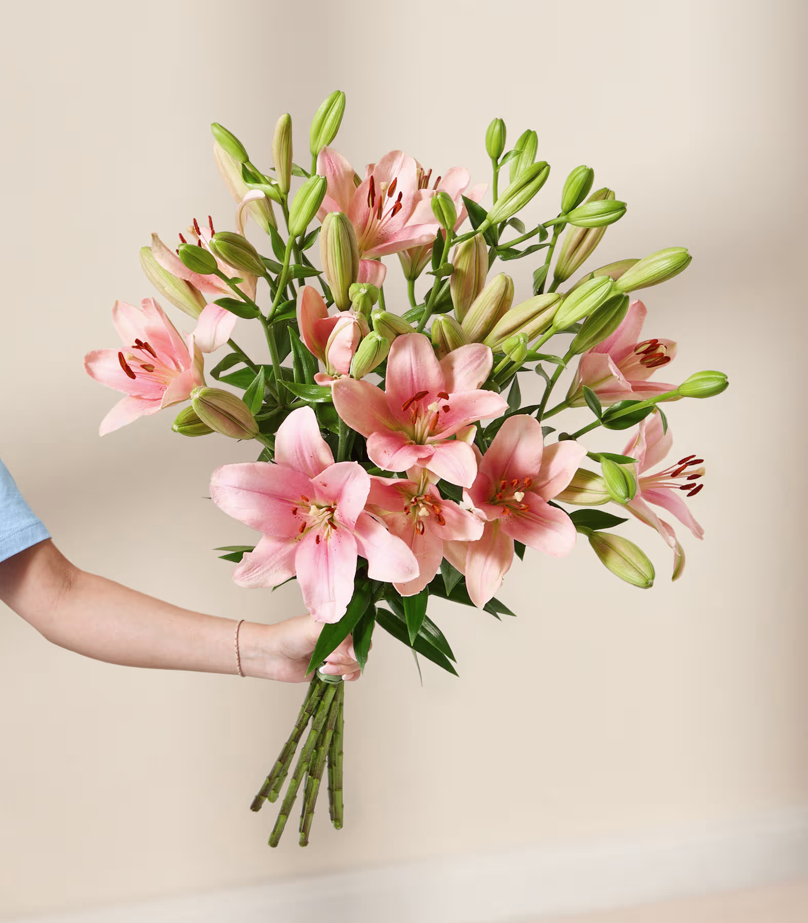 Ein leuchtender Strauß rosa und weißer Tulpen mit grünen Blättern vor schlichtem weißen Hintergrund. (Beschreibungstext KI-generiert)